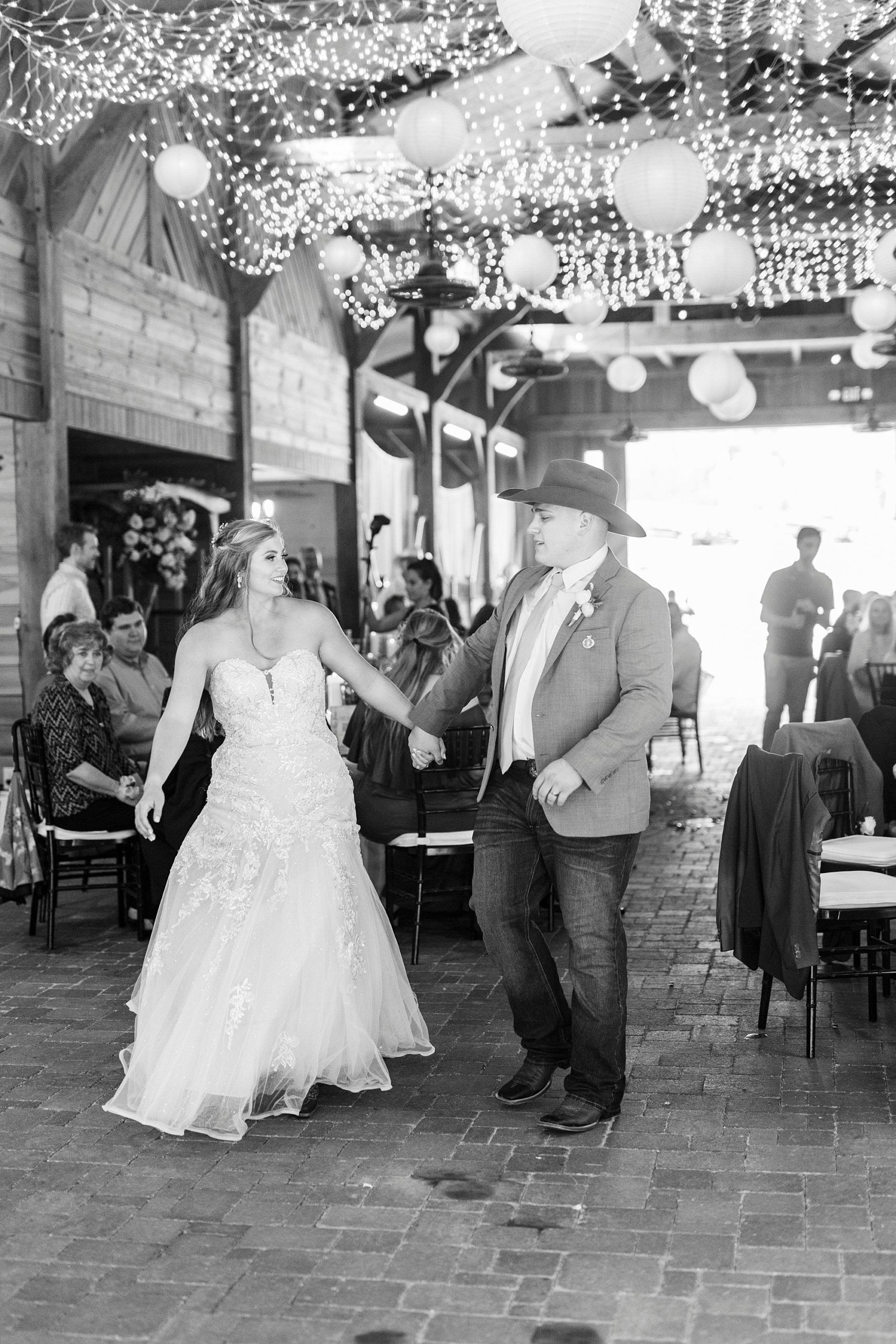 bride and groom hold ands walking into barn at The Stable at Riverview
