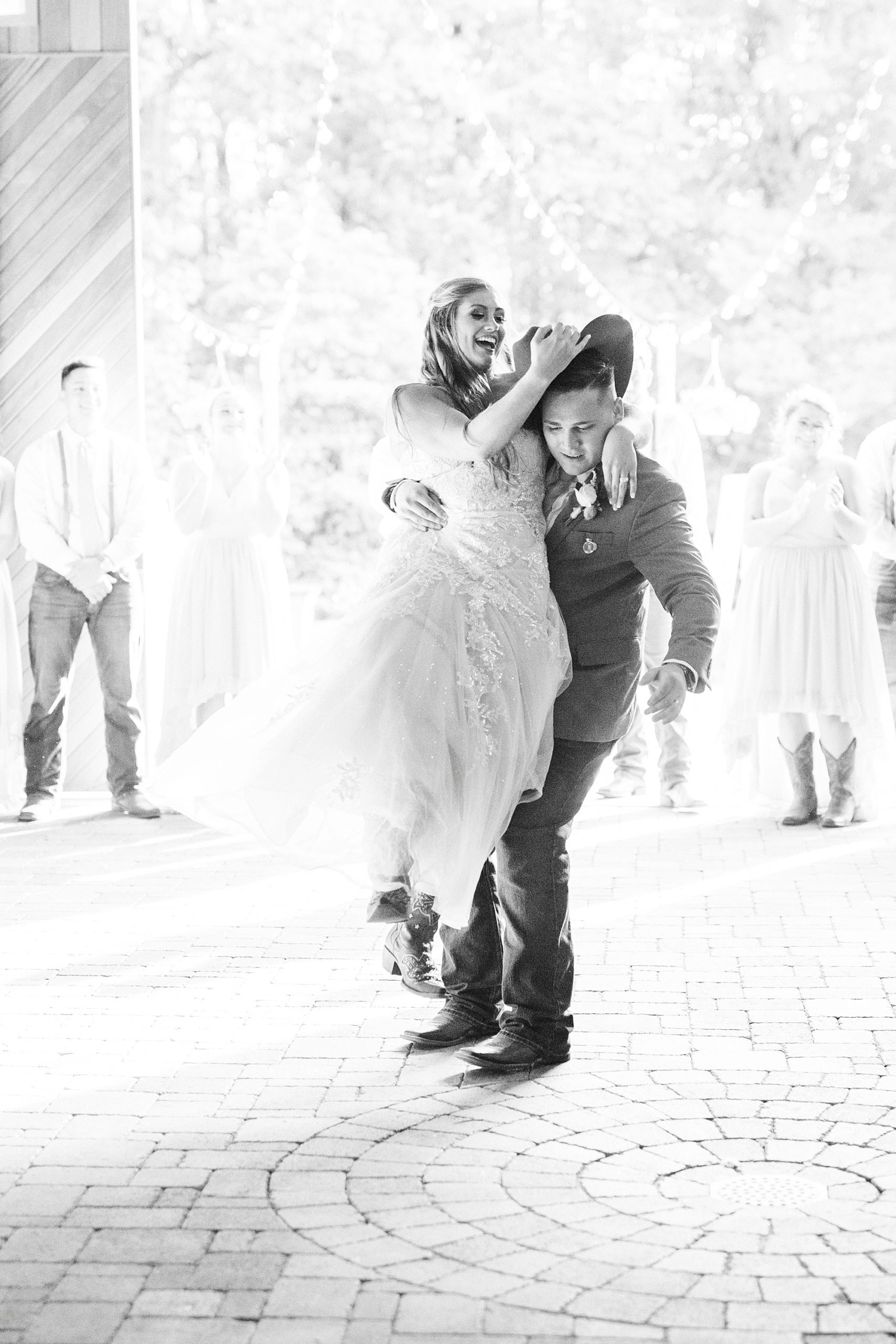 groom lifts up bride during reception