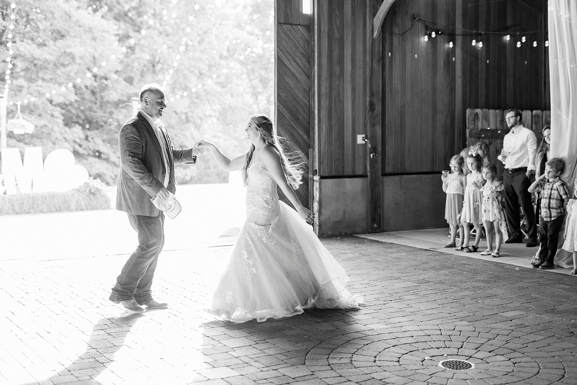 bride and dad dance in barn at The Stable at Riverview