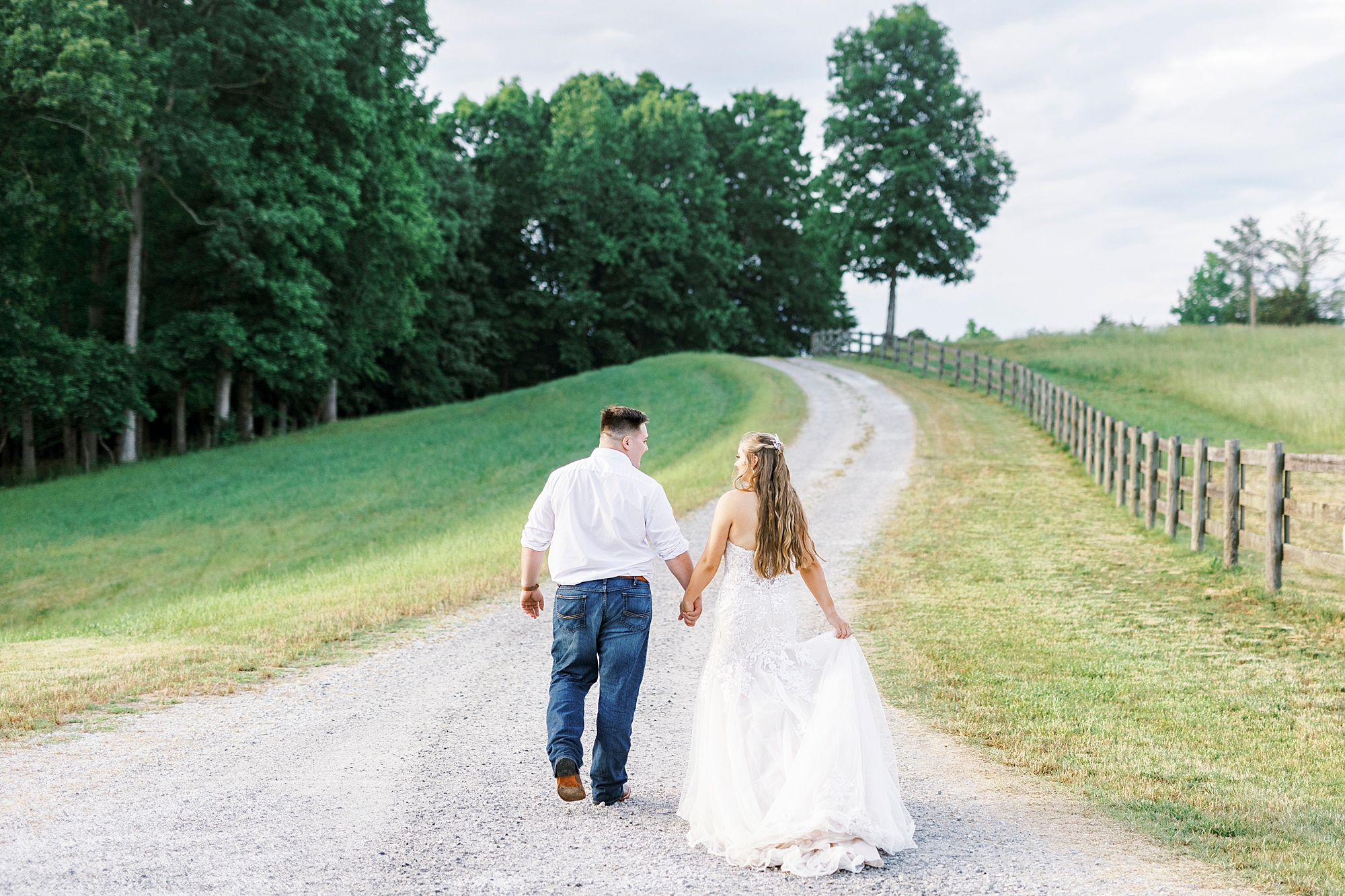 bride and groom walk up hill at The Stable at Riverview