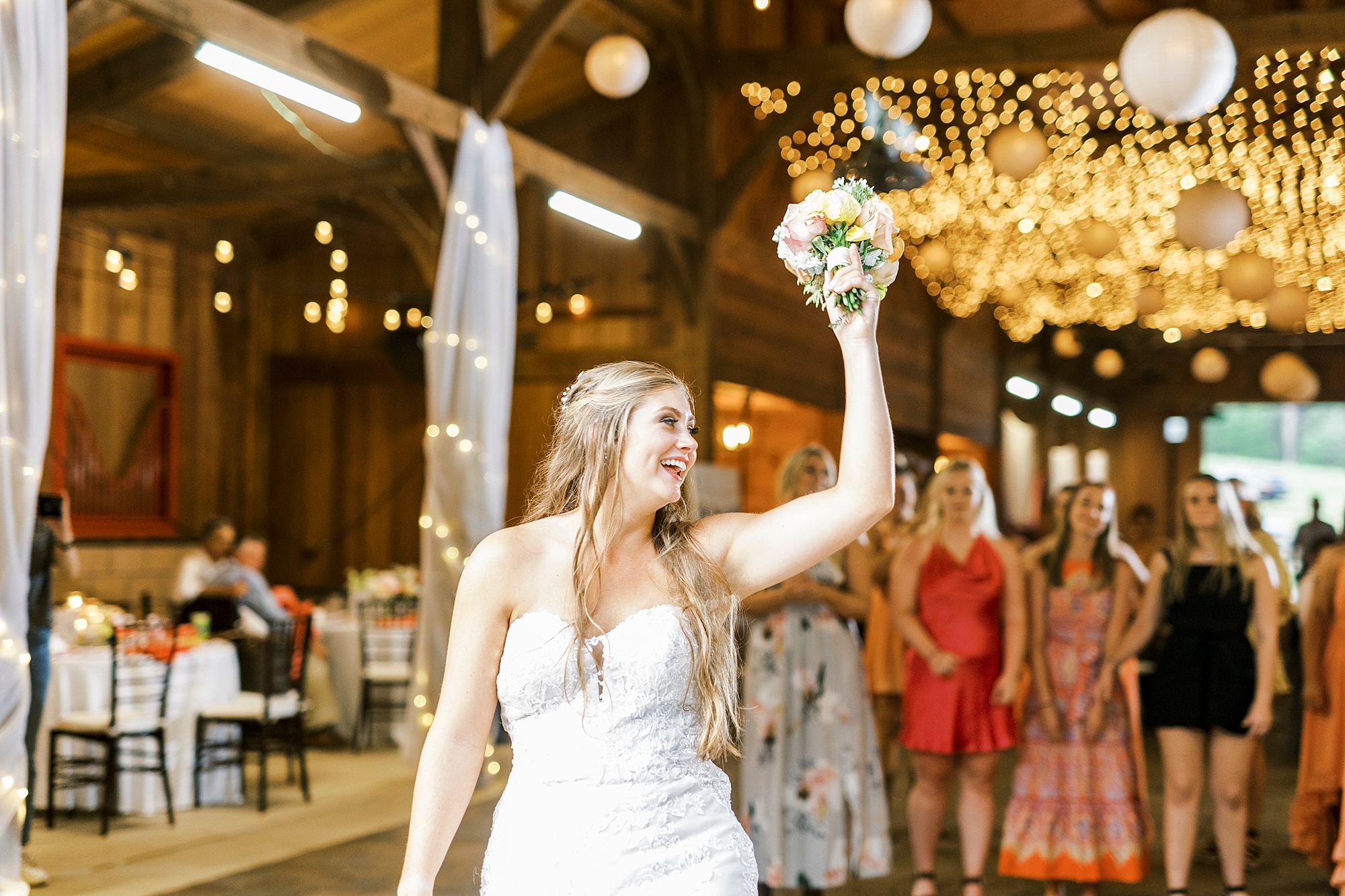 bride tosses bouquet during NC wedding reception 