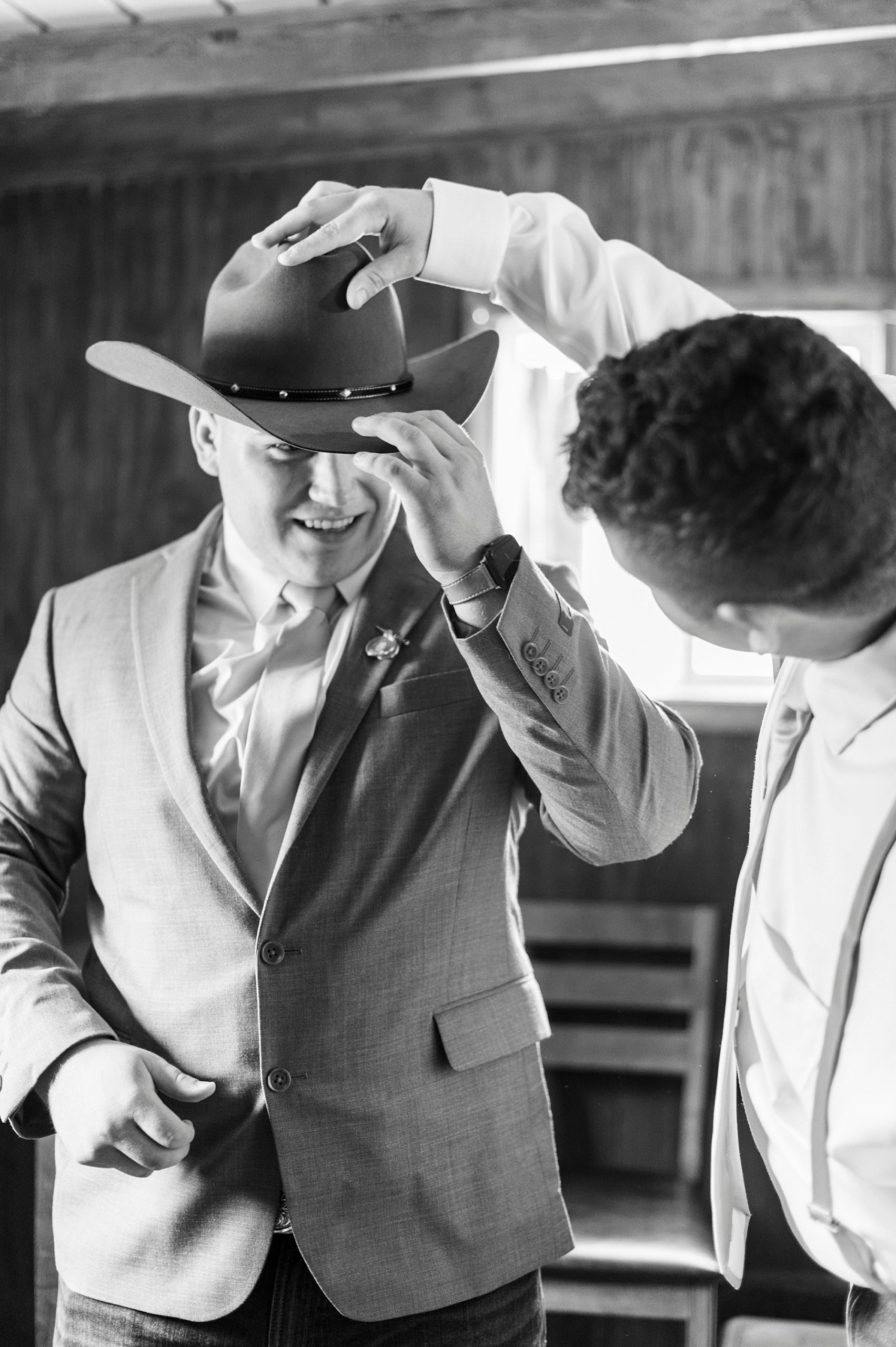 groom adjusts cowboy hat before The Stable at Riverview wedding 