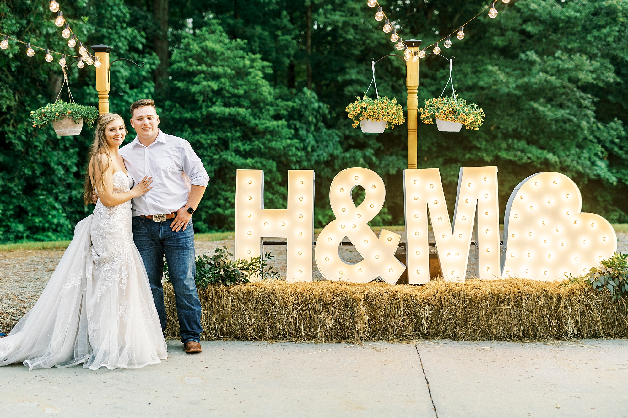 bride and groom stand by marquee letters at The Stable at Riverview