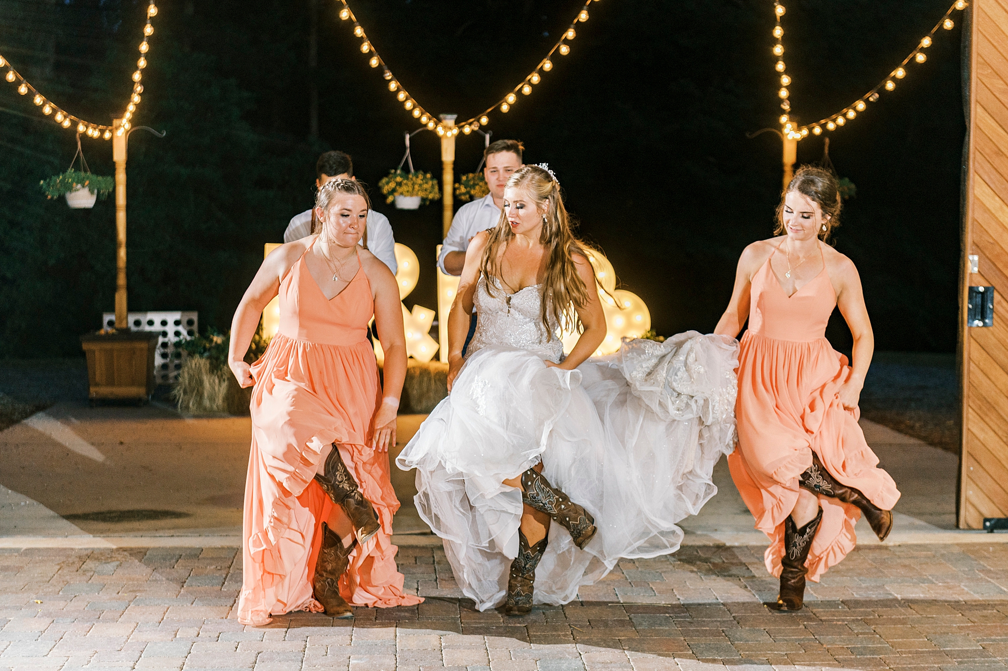 bride and bridesmaids dance with cowboy boots at The Stable at Riverview