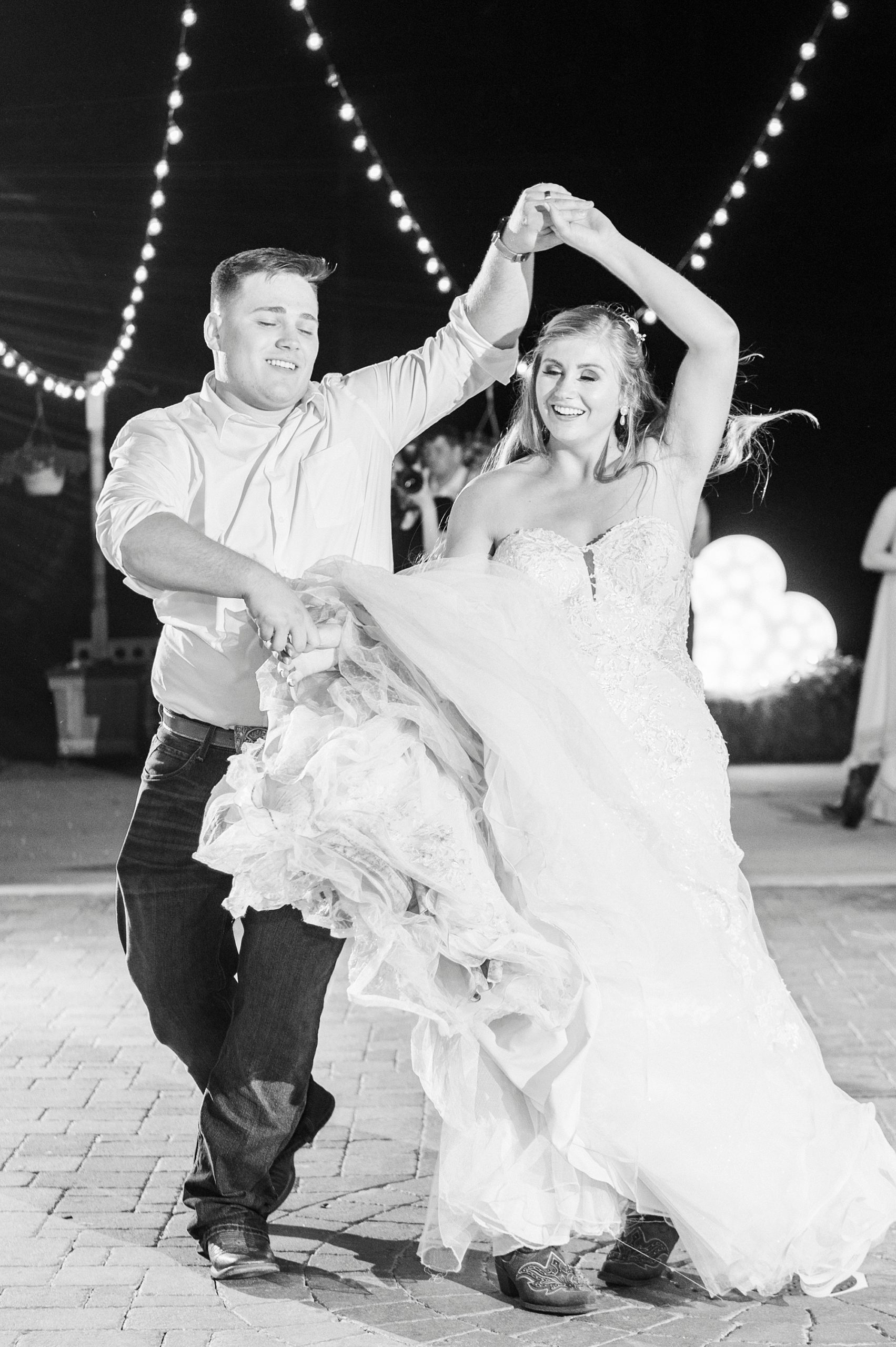 groom twirls bride during wedding reception dancing