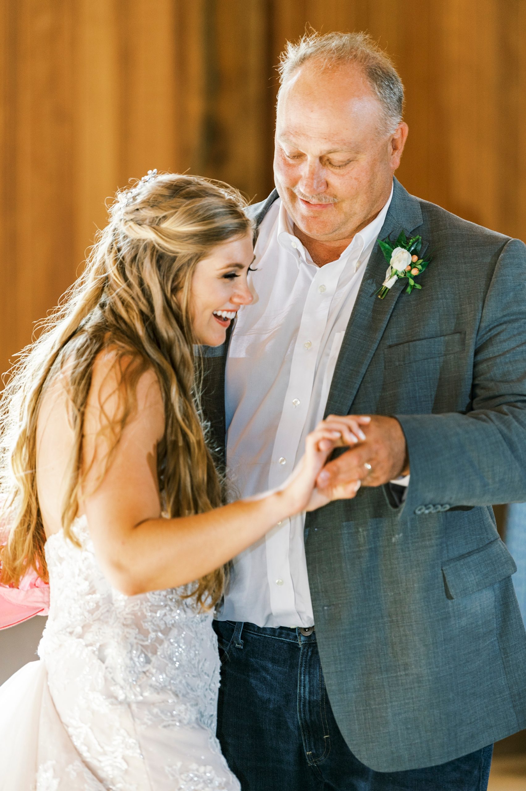 bride smiles dancing with dad during reception