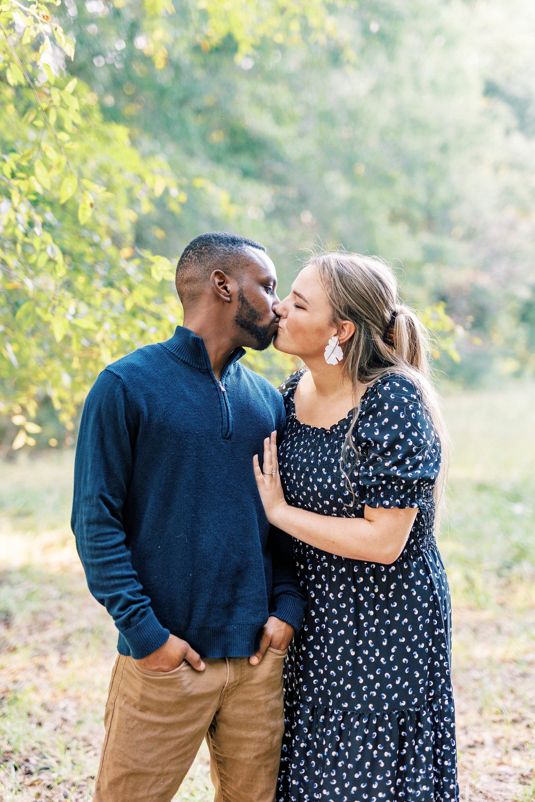 engaged couple kisses among fall leaves in Indian Trail NC
