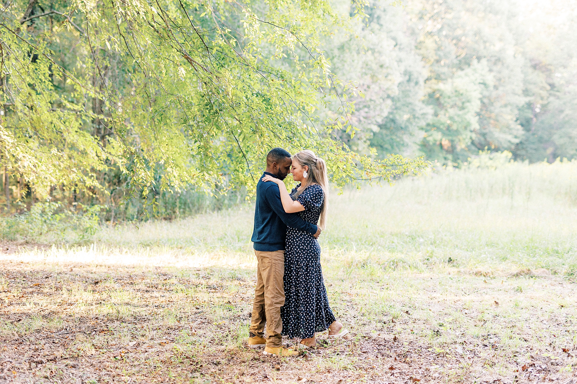 engaged couple hugs standing on fallen leaves at Bella Terra