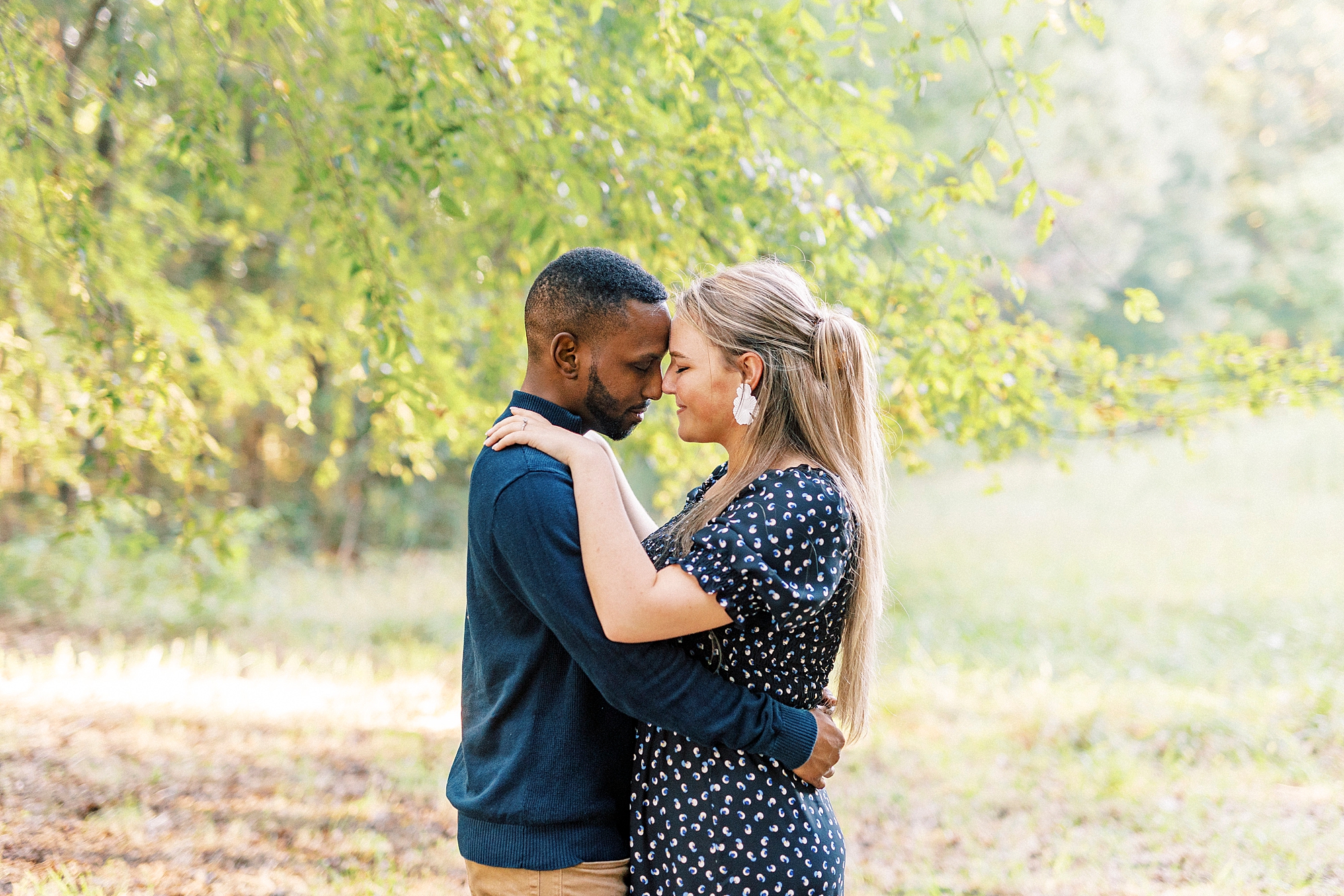 couple hugs under trees during NC engagement session