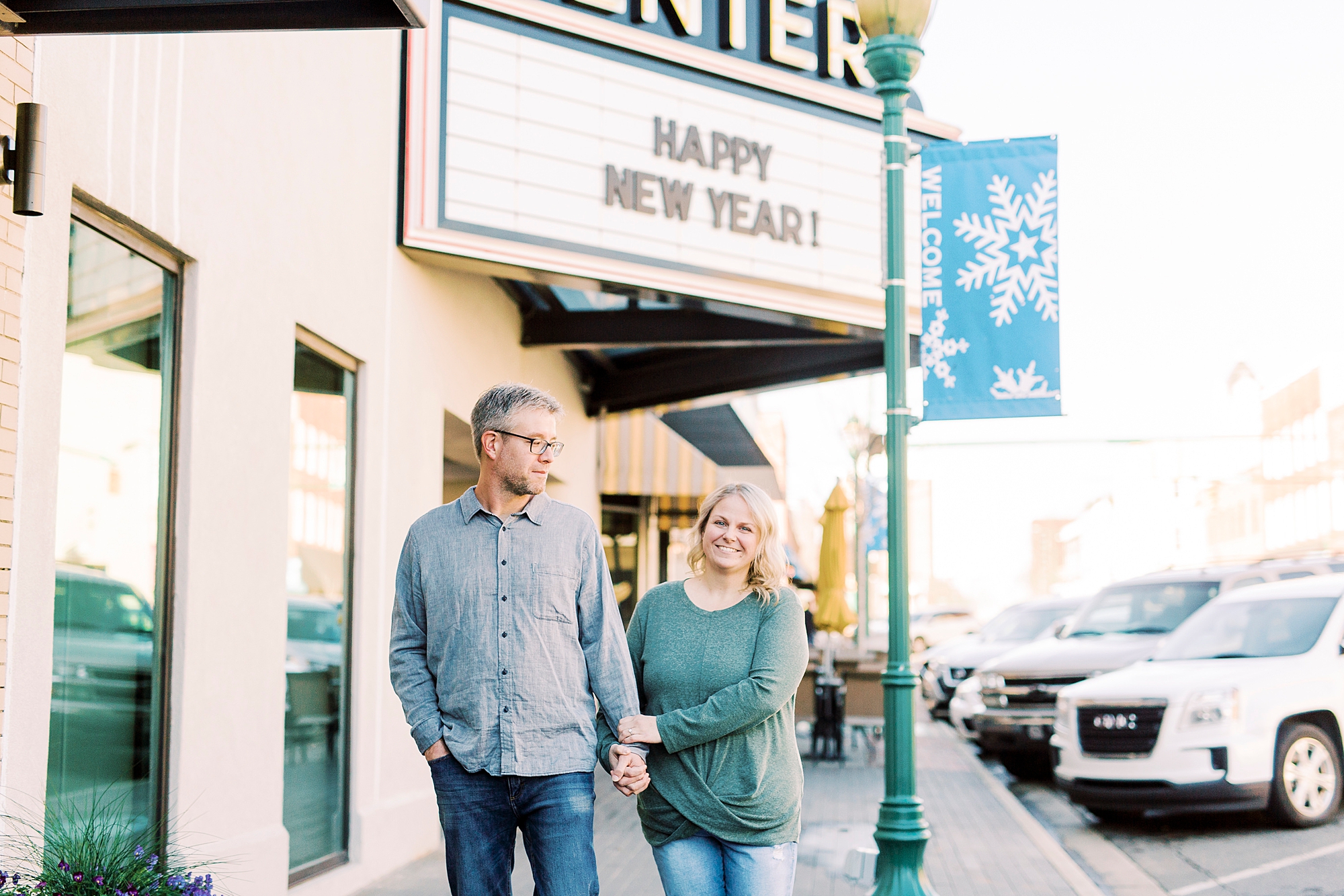 couple poses outside movie theatre in Downtown Monroe
