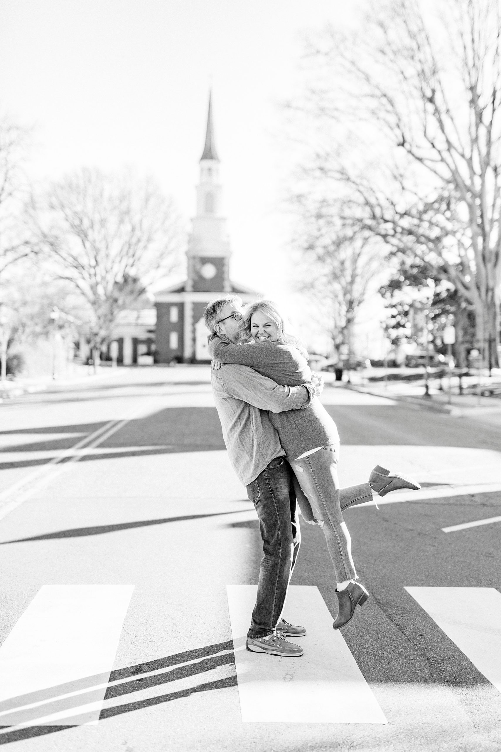 bride and groom hug in middle of street during Downtown Monroe engagement portraits