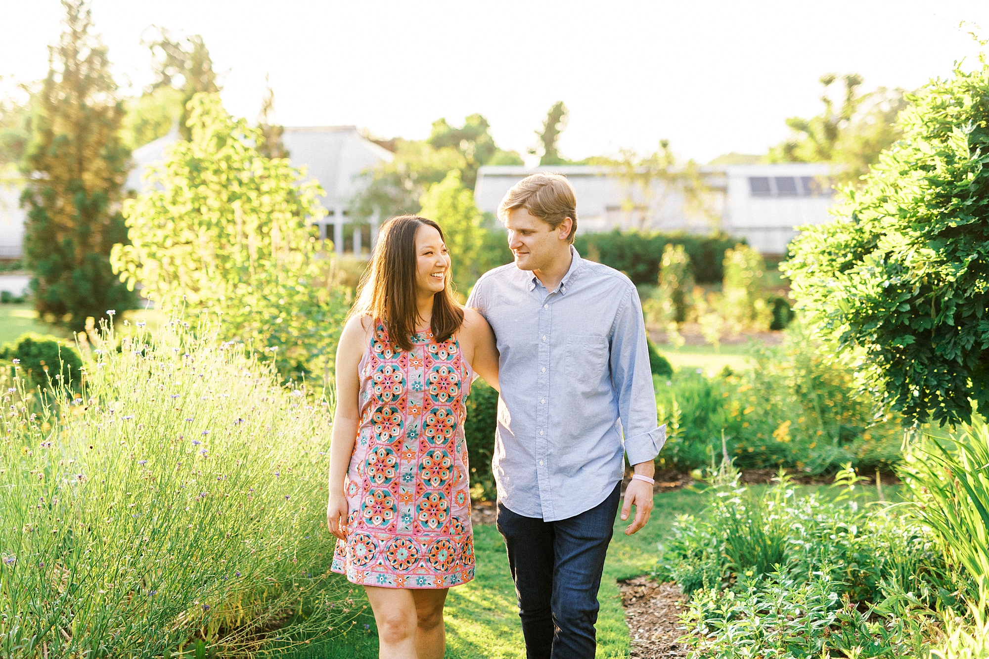 bride and groom walk through gardens during Winston-Salem engagement session