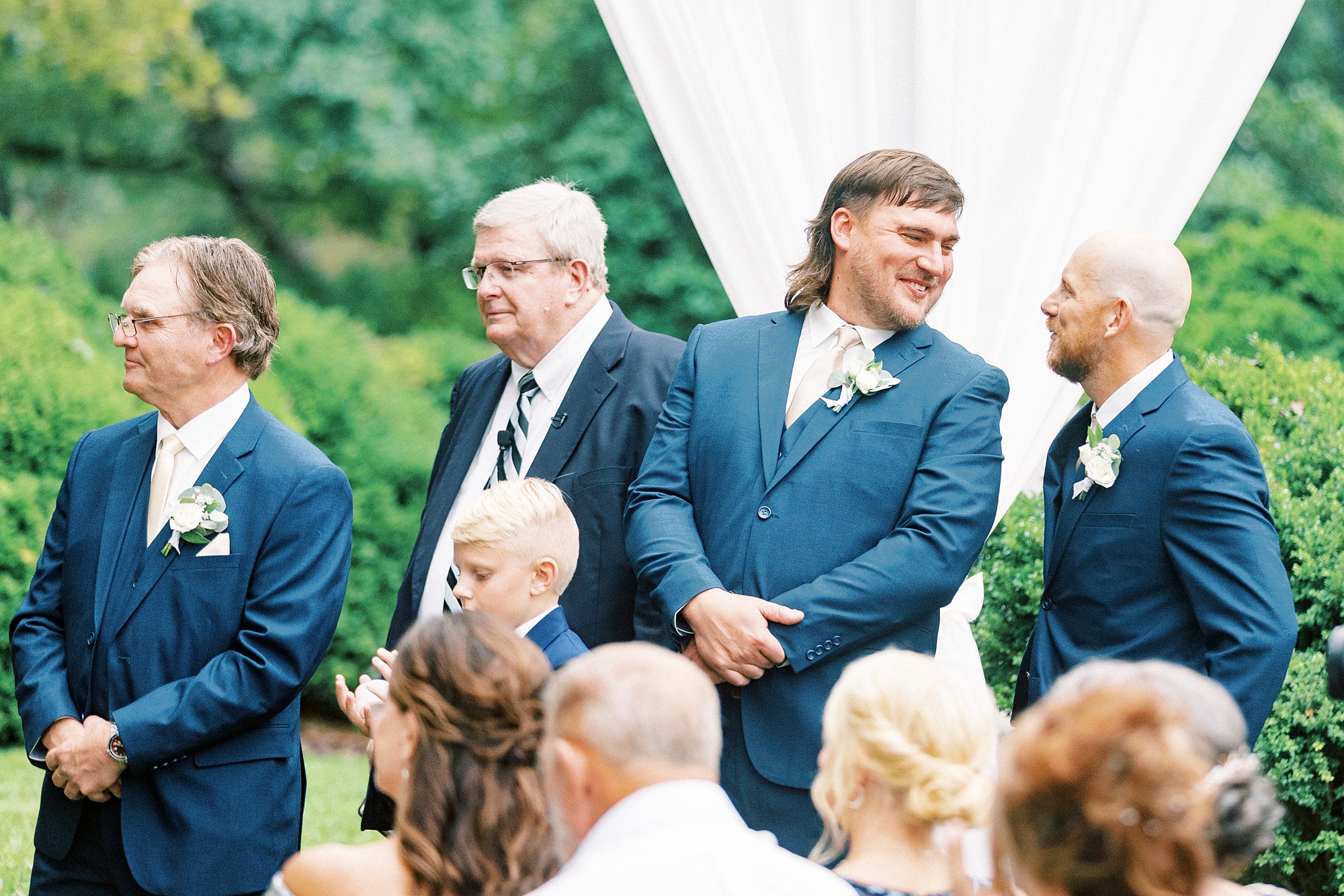 groomsman smiles at friend during  Boxwood Estate wedding ceremony 