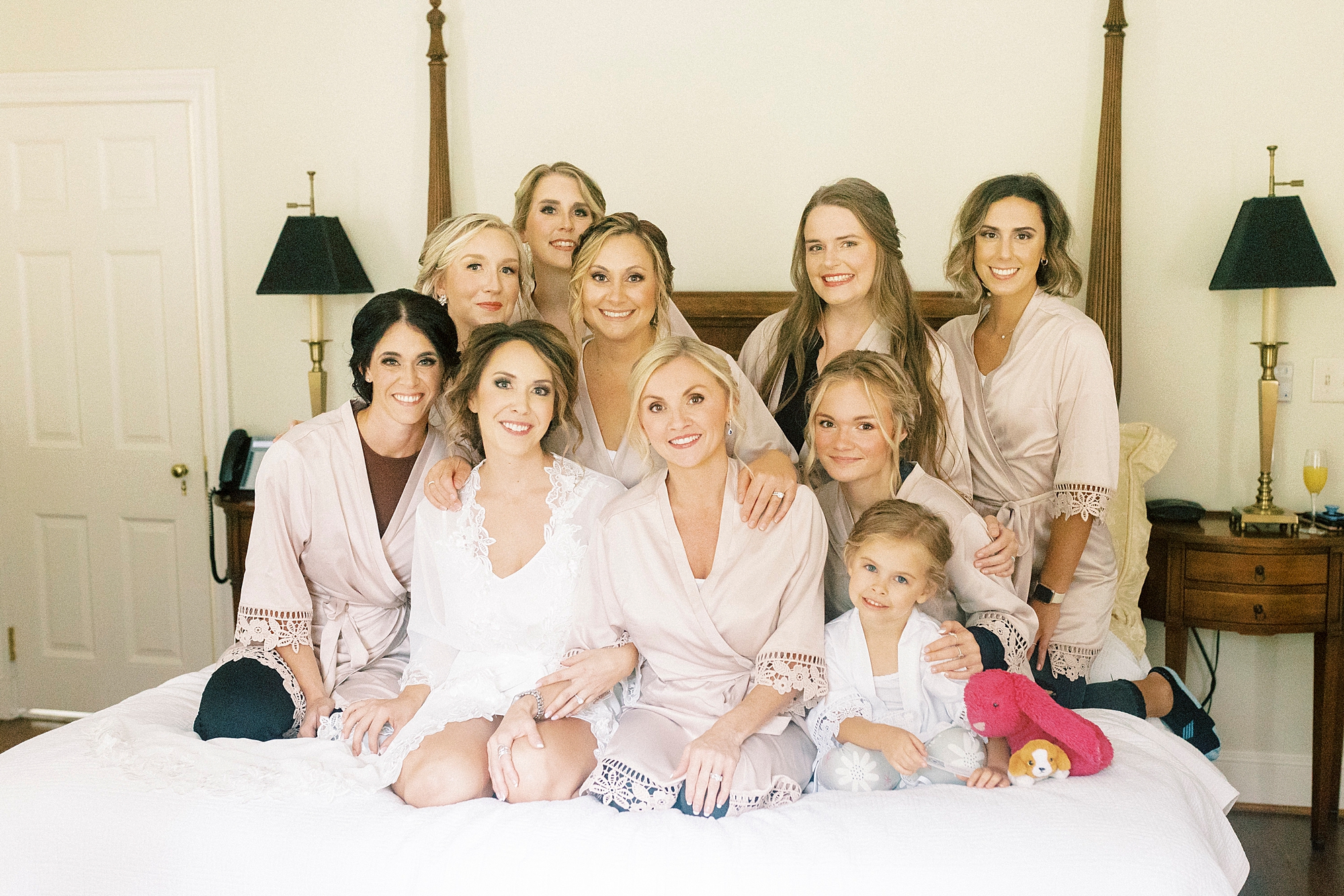 bride sits with bridesmaid on bed at Boxwood Estate