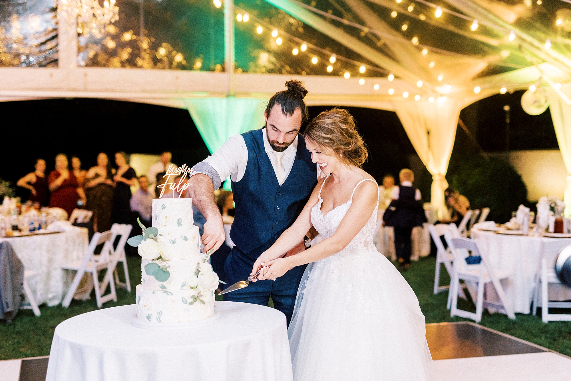 bride and groom cut wedding cake during NC wedding reception