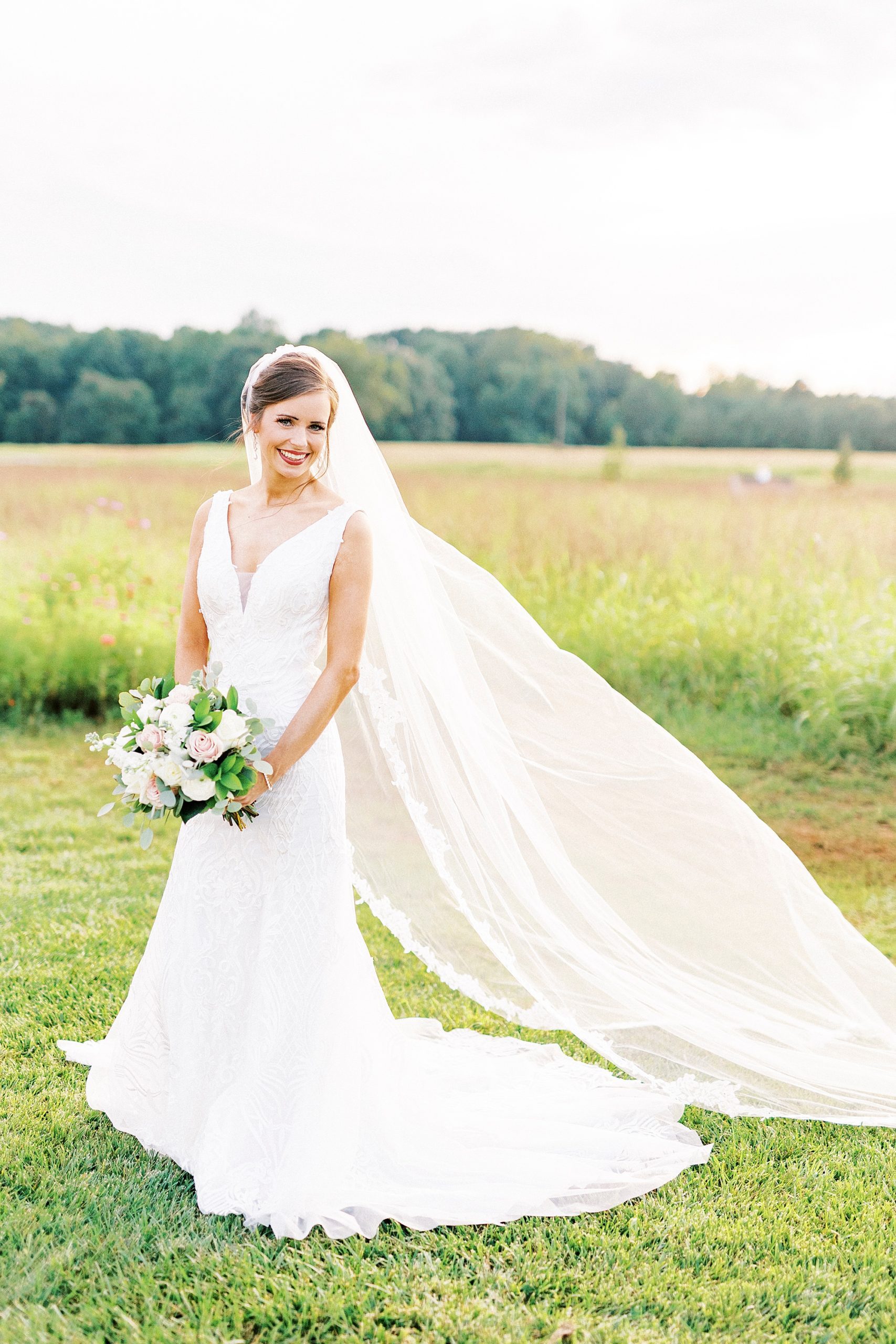 bride smiles with veil floating behind her at Chickadee Hill Farms