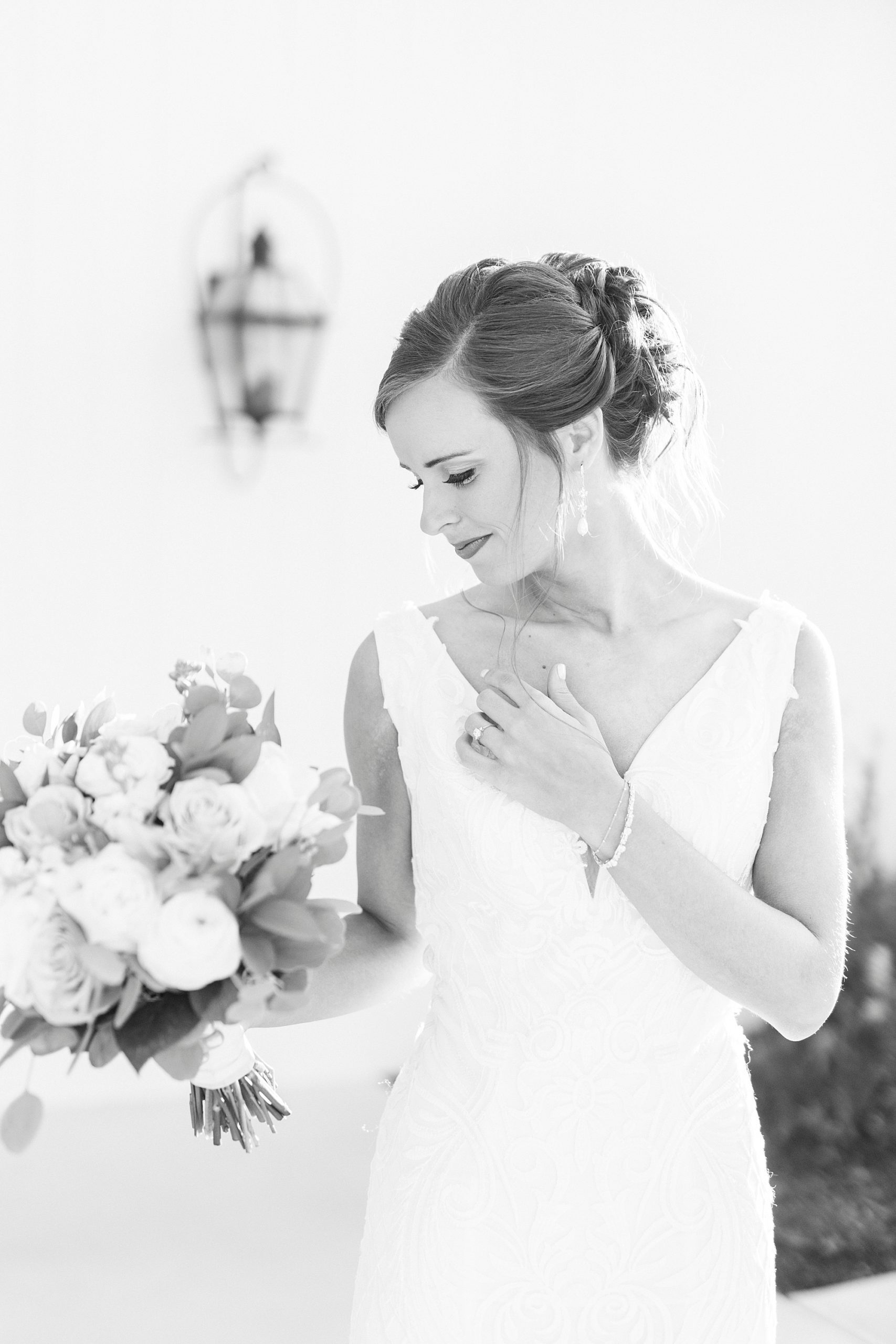 black and white bridal portrait of bride looking at bouquet