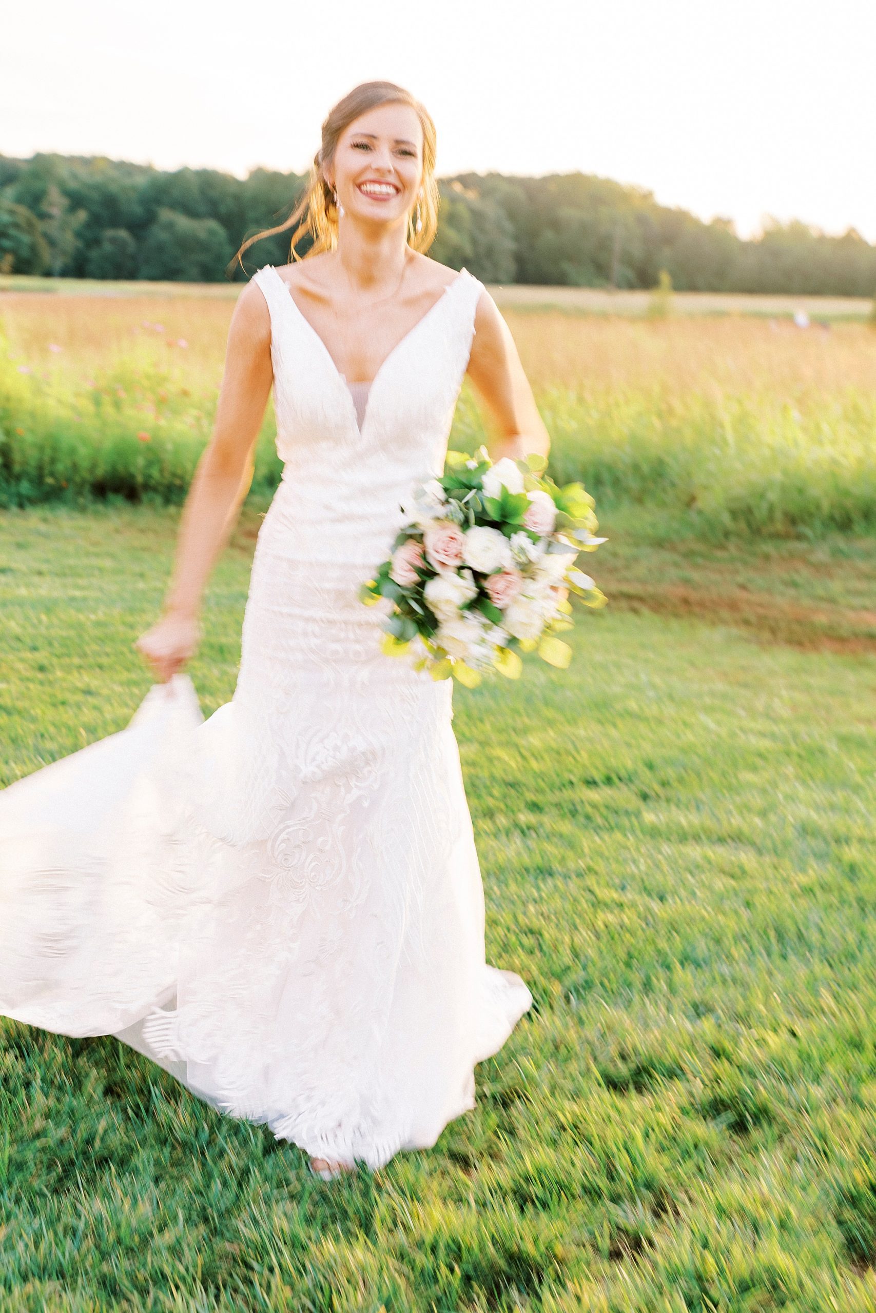 bride holds bouquet walking in field at Chickadee Hill Farms