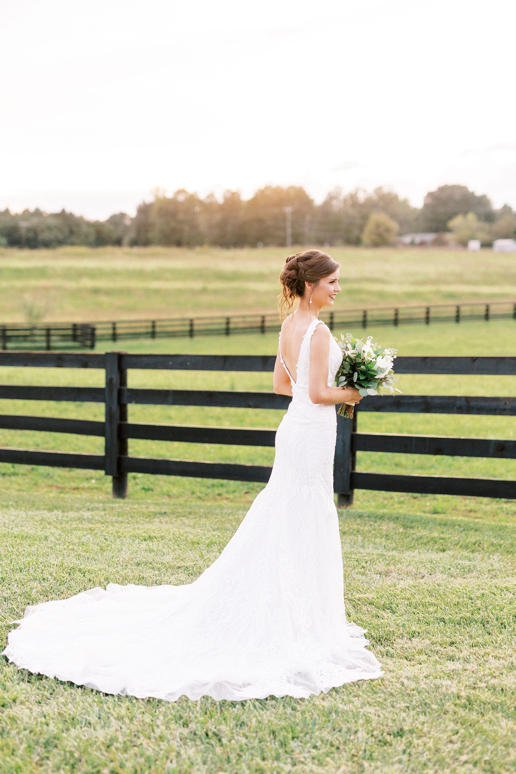 bride stands along black fence at Chickadee Hill Farms