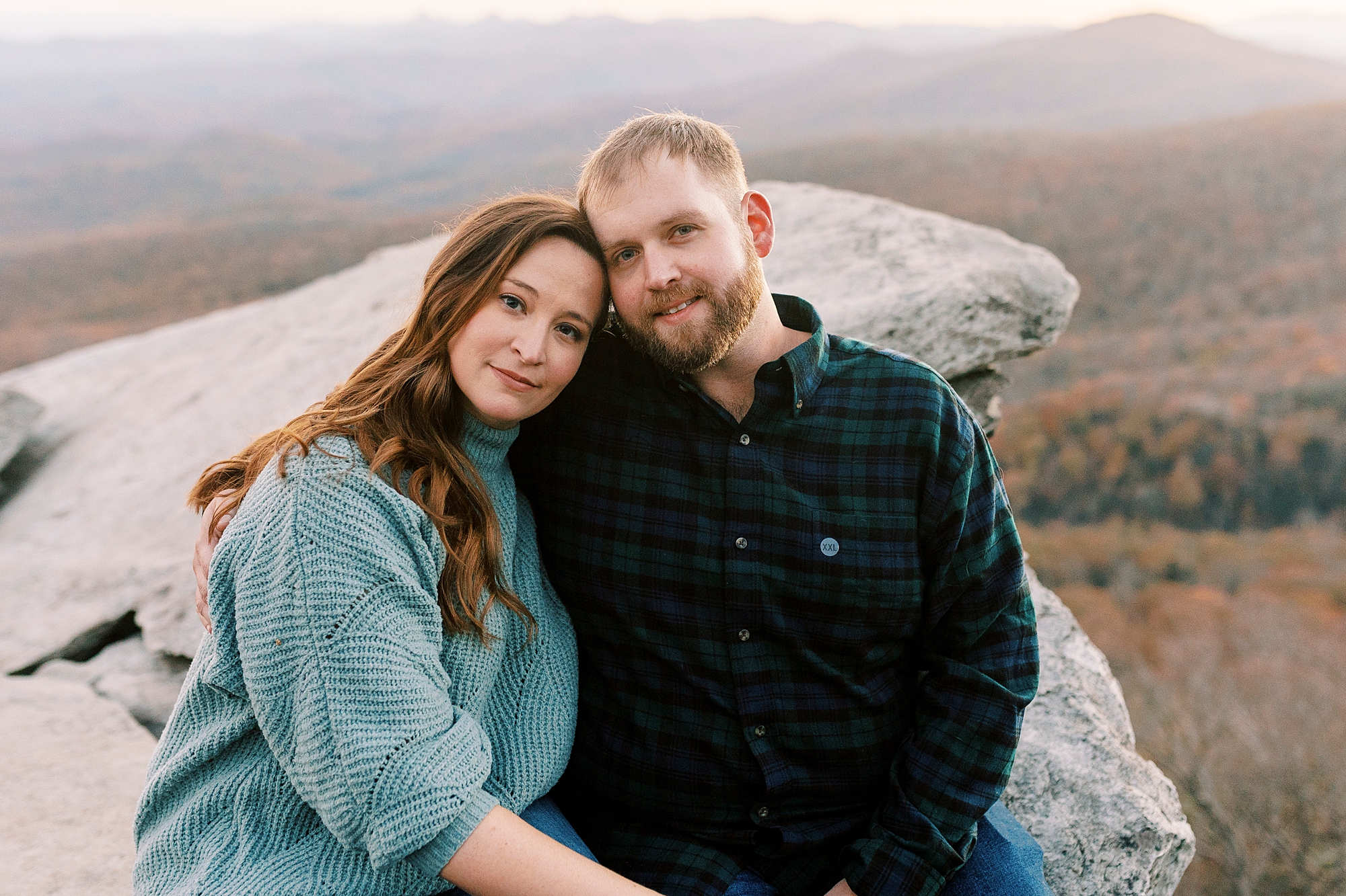 engaged couple sits on Rough Ridge in the Blue Ridge Parkway