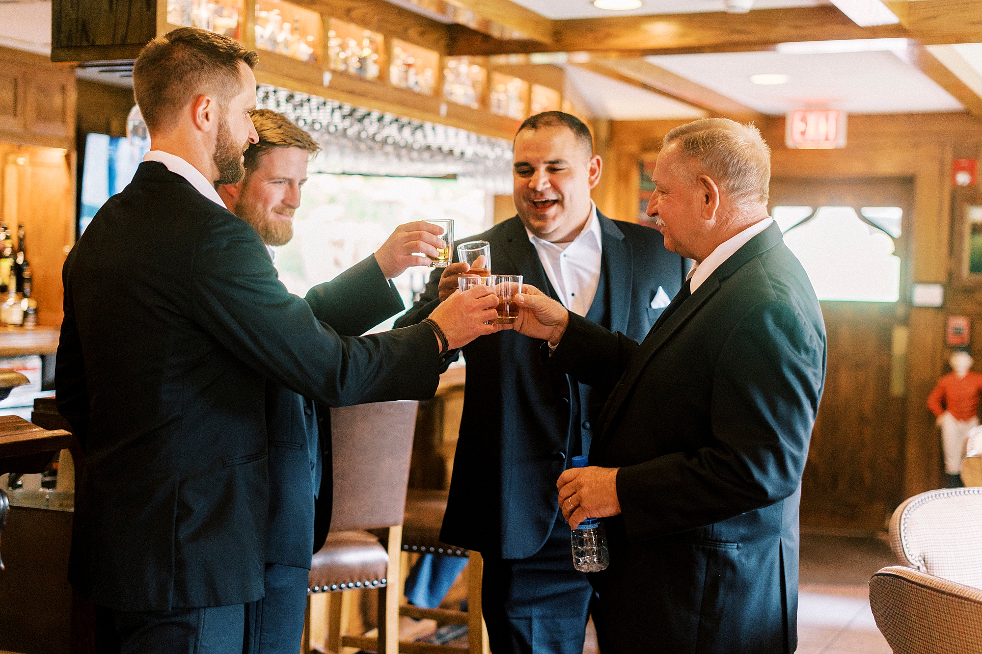 groom and groomsmen toast scotch during prep for wedding at Chetola Resort