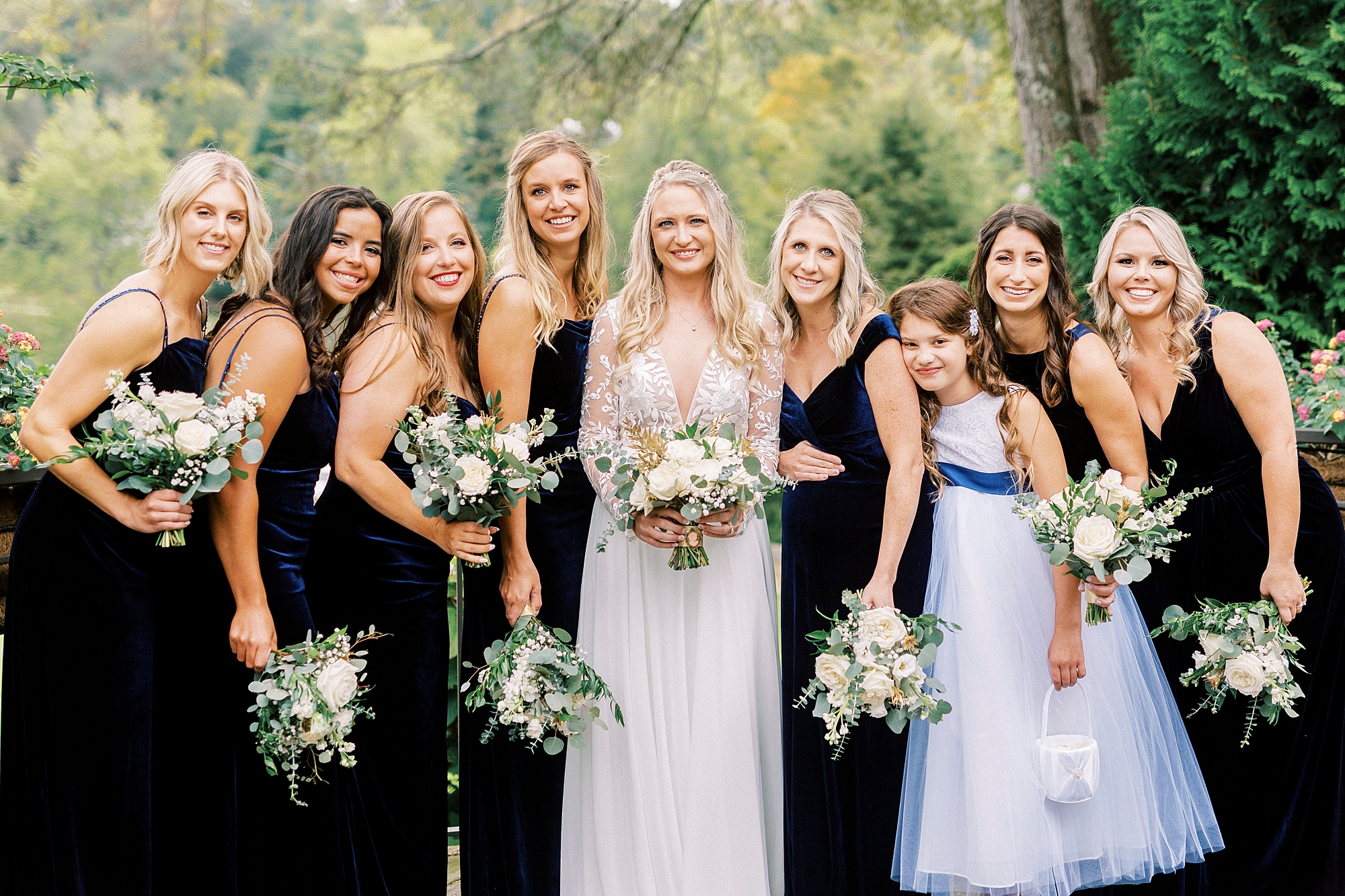 bride stands with bridesmaids in black gowns before Chetola Resort wedding