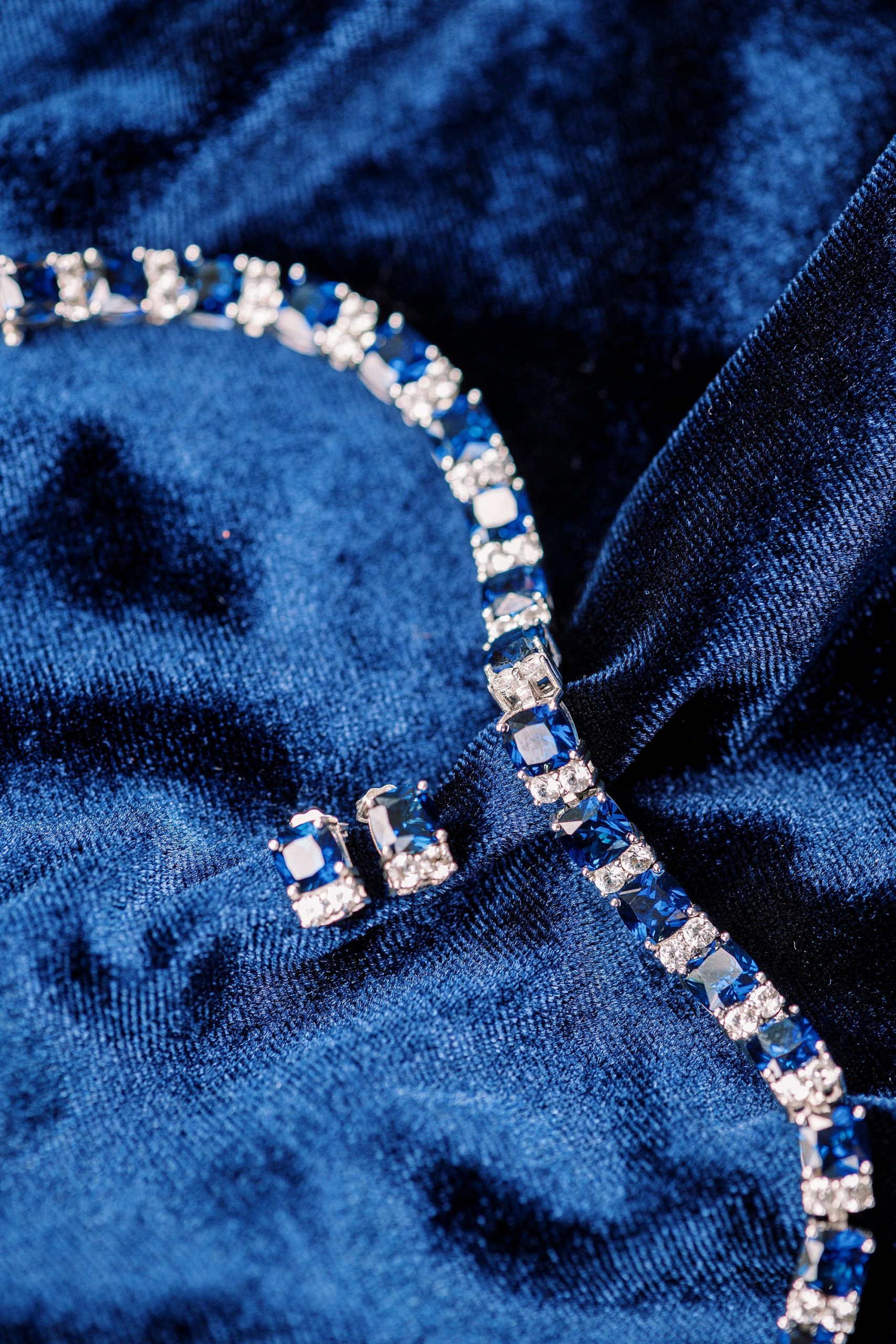 bride's sapphire and diamond jewelry on blue bag