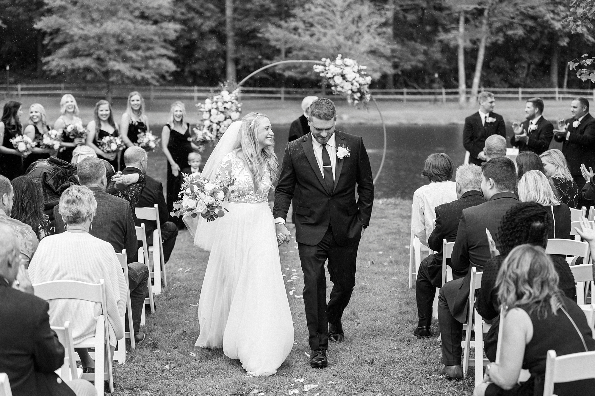 bride and groom hold hands walking up aisle at Chetola Resort