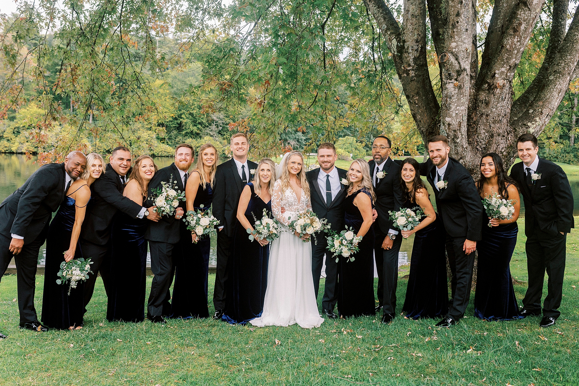 bride and groom stand with wedding party in black at Chetola Resort