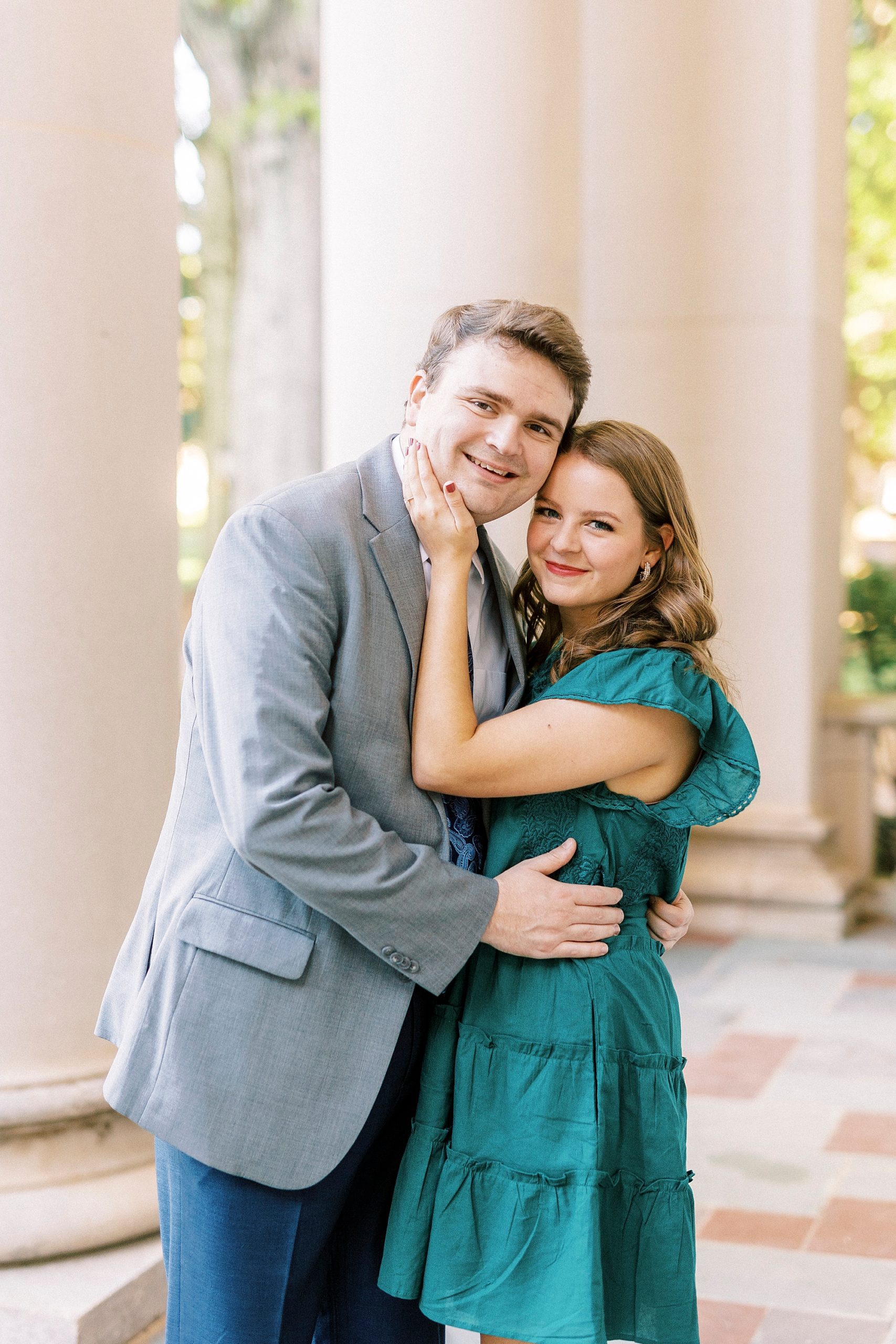 bride hugs groom to her during Downtown Davidson engagement portraits 