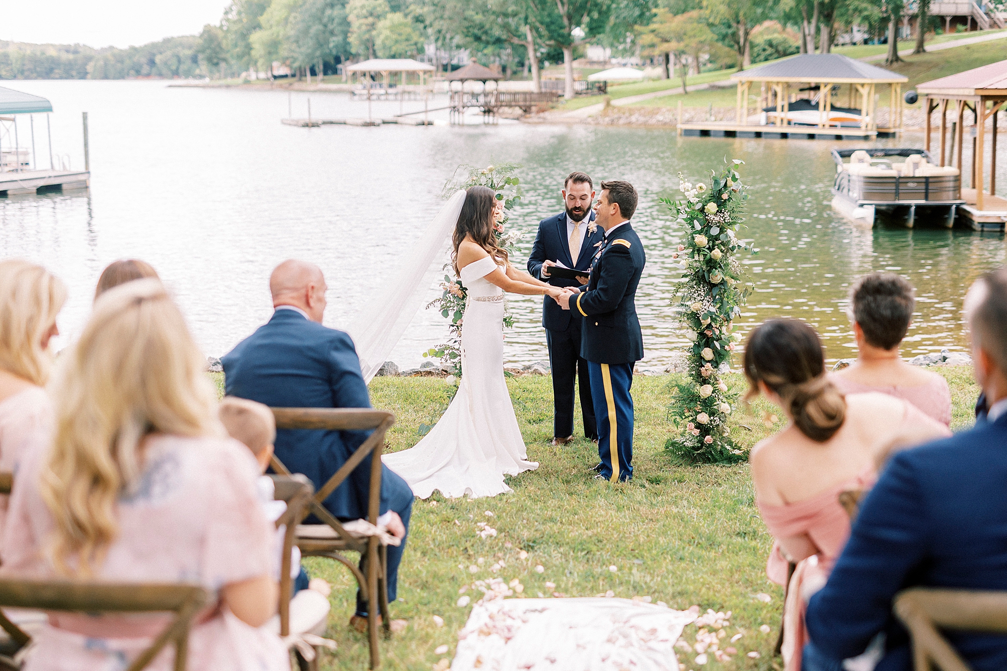 bride and groom hold hands at end of aisle during Lake Norman wedding ceremony 