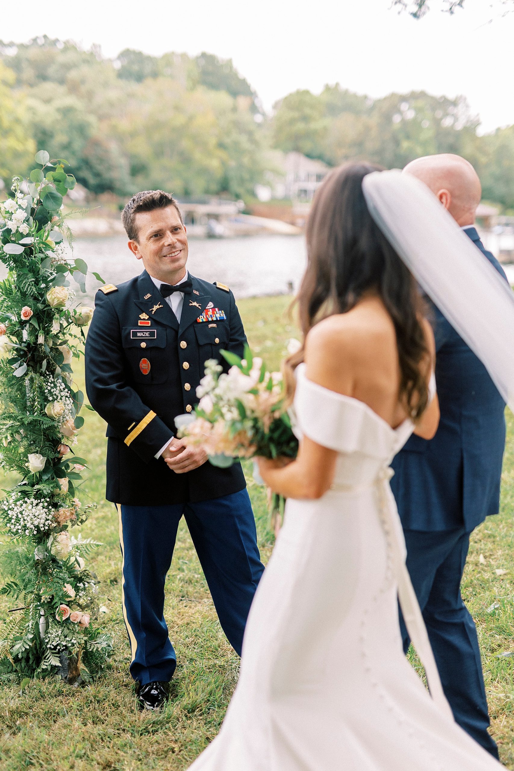 groom smiles at bride and her father at end of the aisle