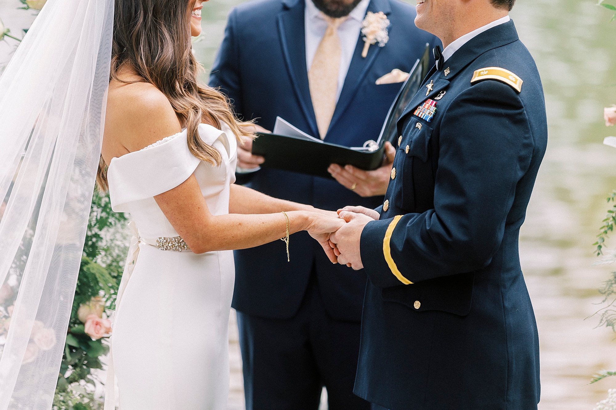 couple holds hands exchanging vows