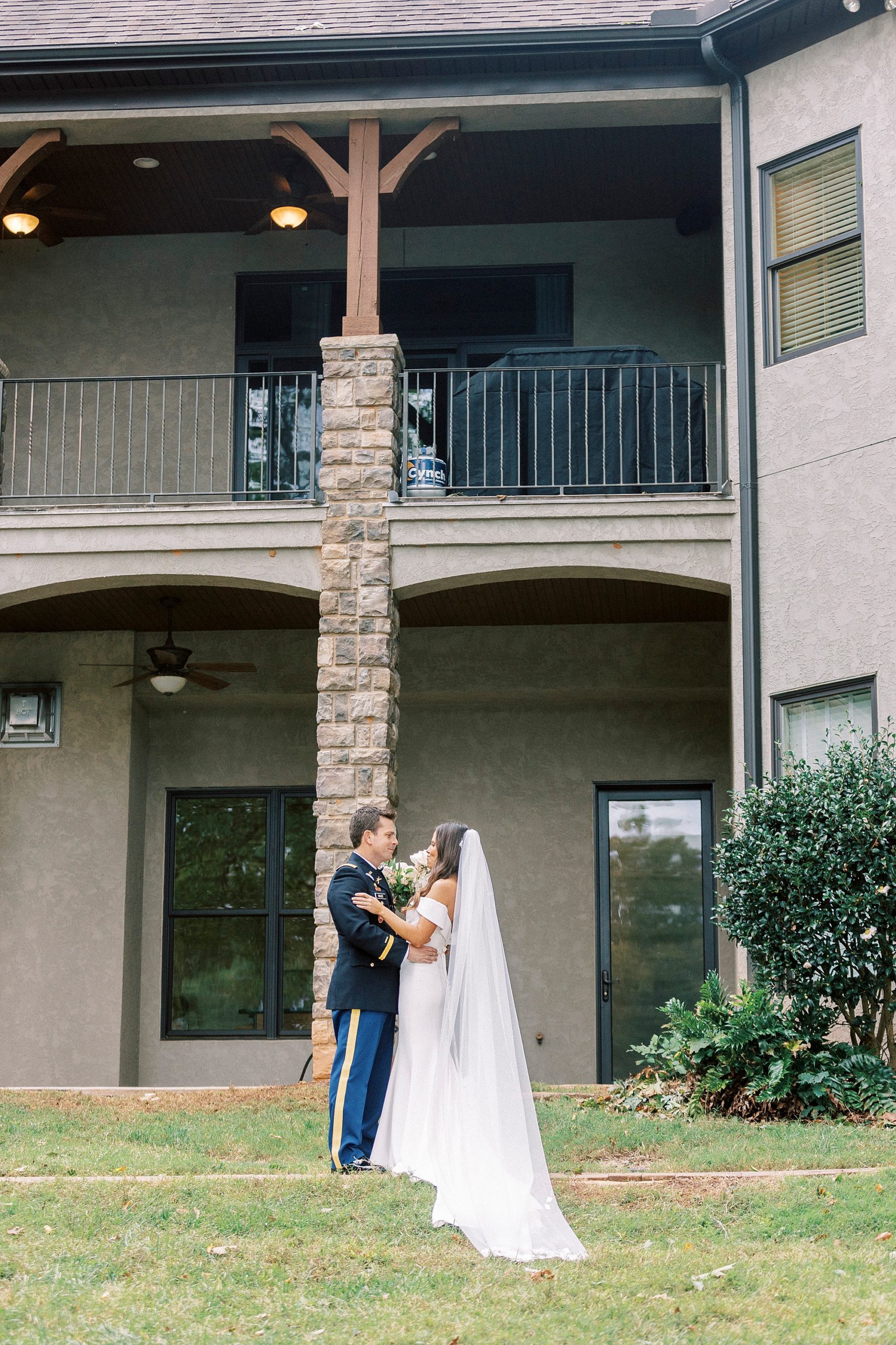 newlyweds pose near patio of Lake Norman home