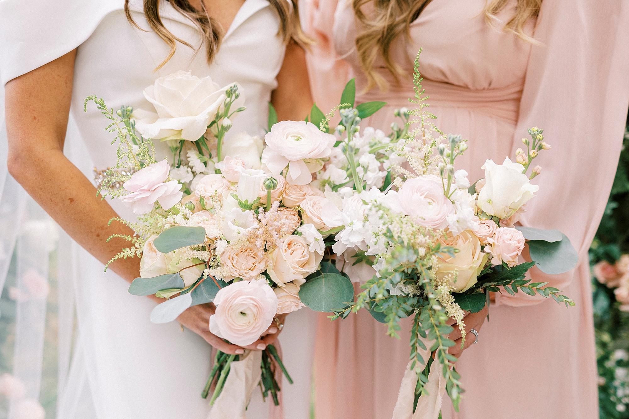 bride holds bouquet of pink and white flowers with woman in pink gown