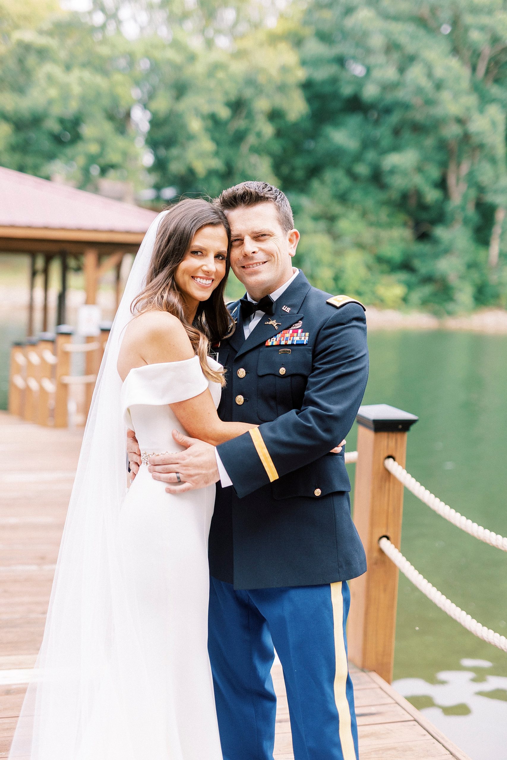 newlyweds hug leaning heads together at Lake Norman