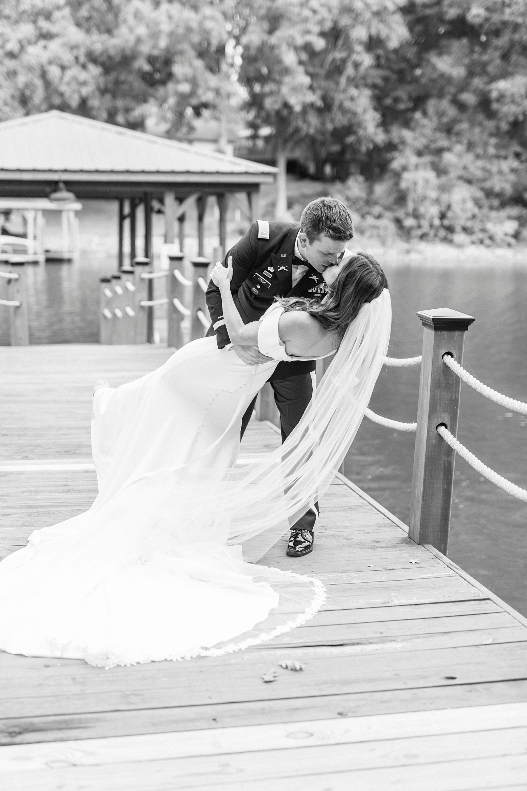 groom dips bride kissing her on Lake Norman wooden dock