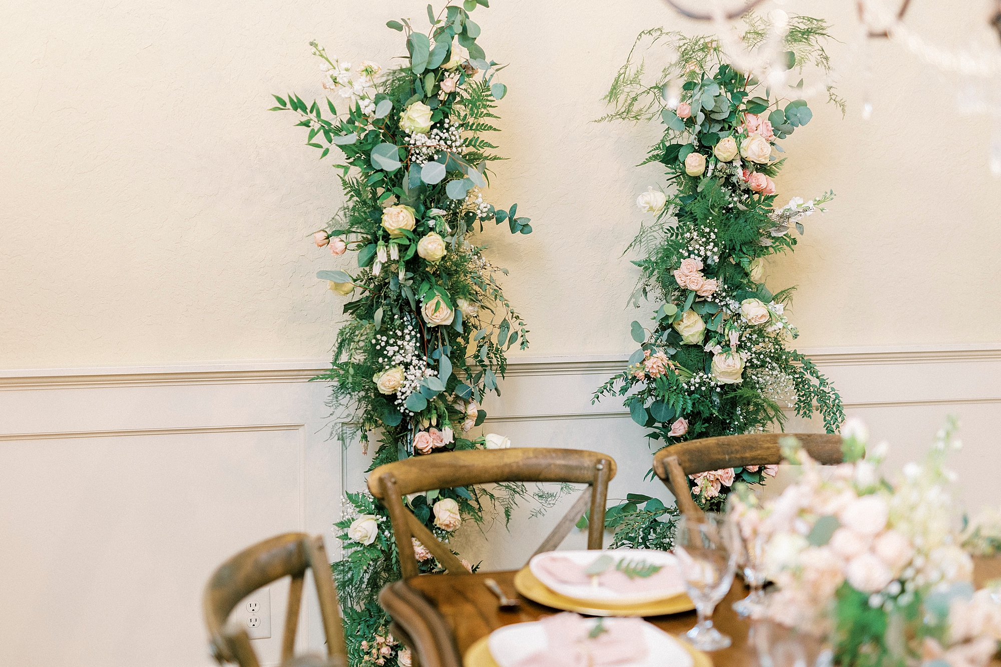 floral display sits behind table for reception 