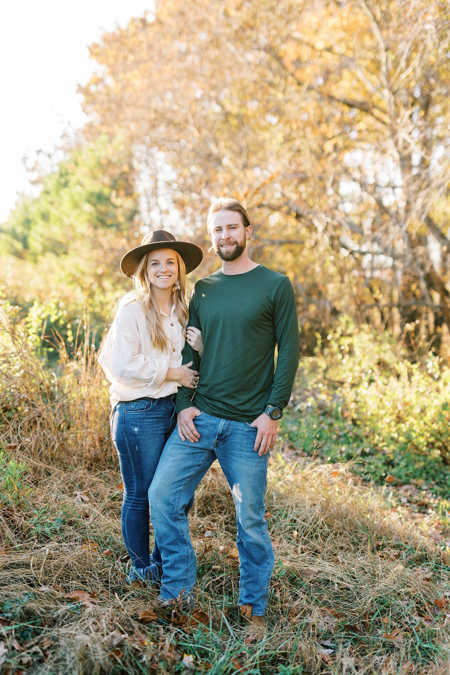 couple poses in field during chic fall engagement session in Richfield NC