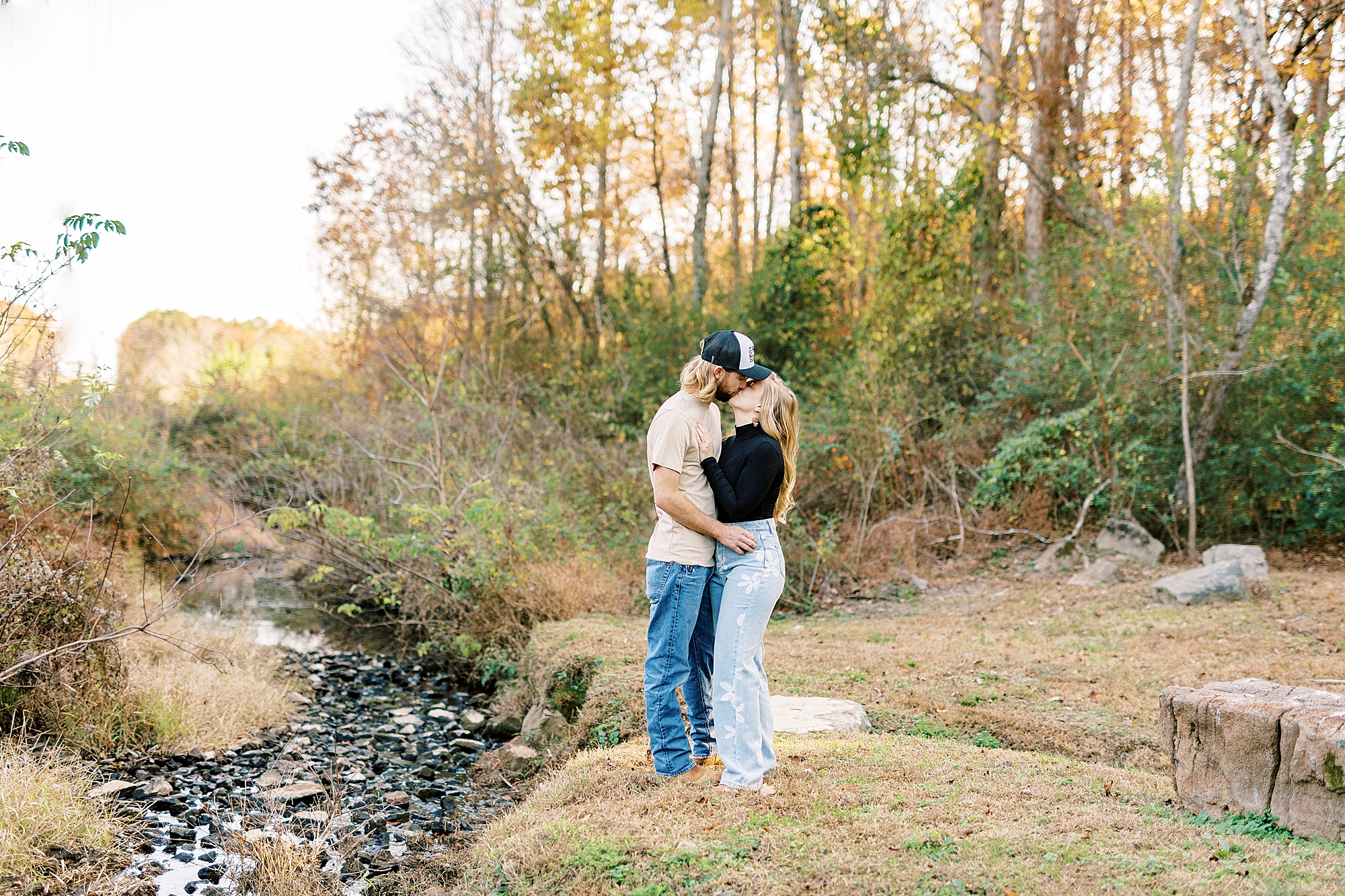 bride and groom kiss beside creek at Richfield NC home
