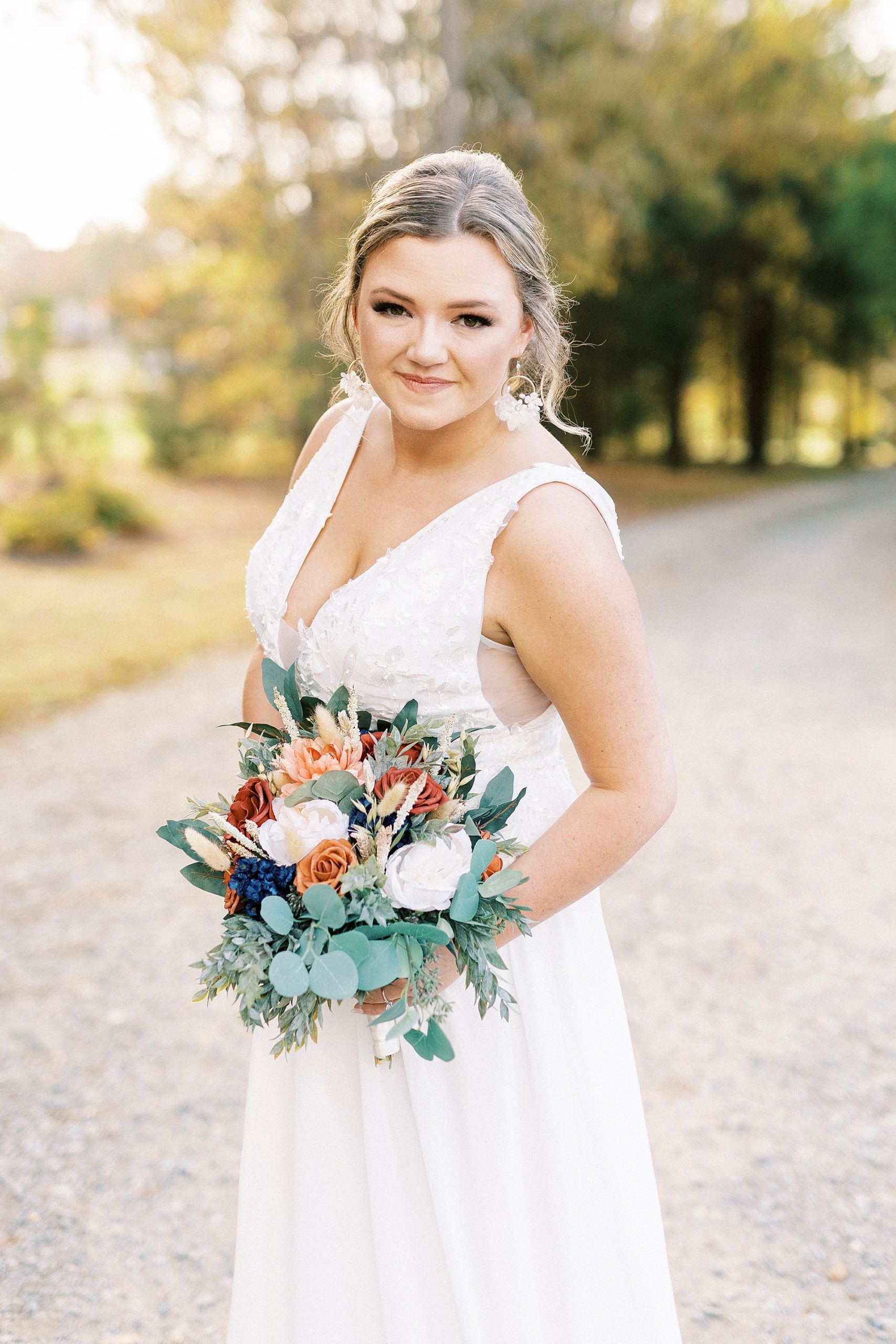 bride holds bouquet of peach and orange flowers at Bella Terra 
