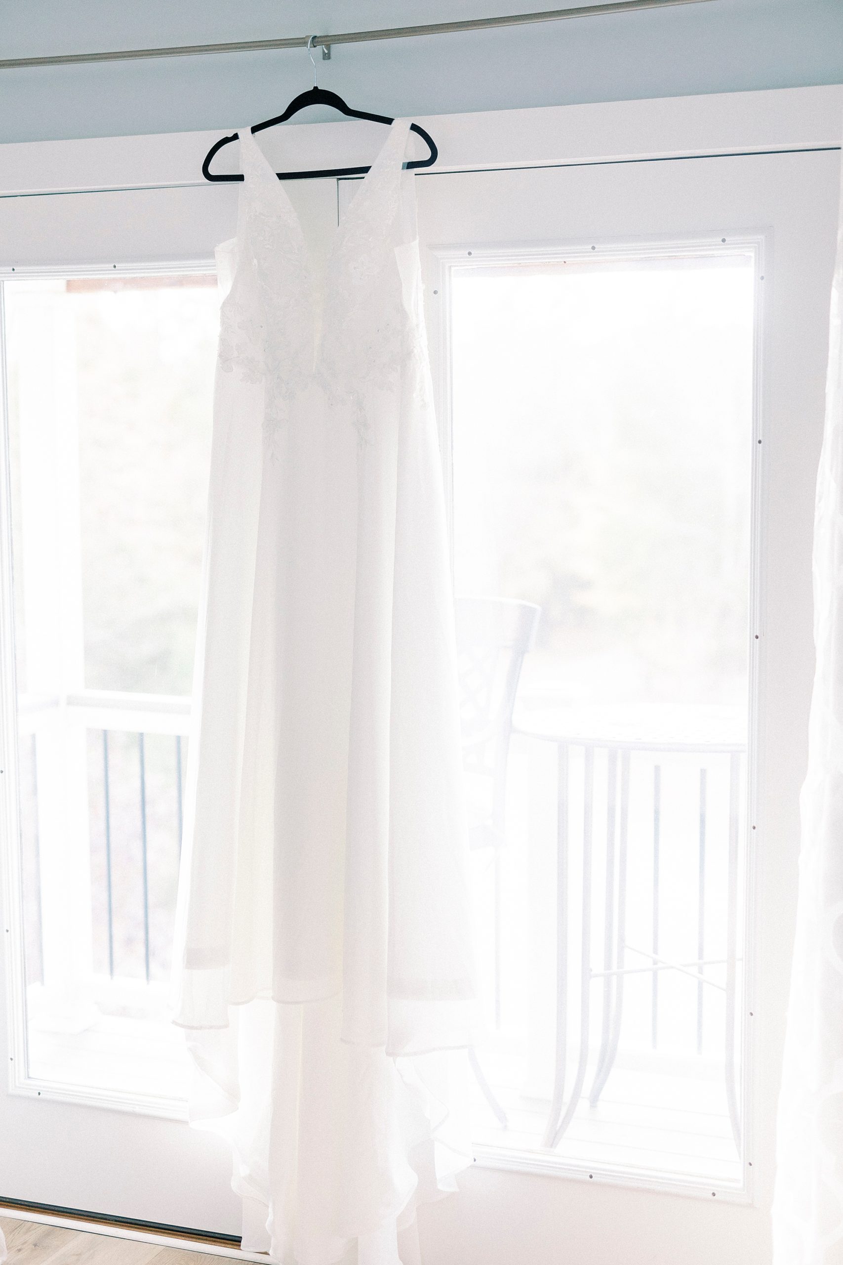 wedding dress hangs in window at Bella Terra Inc bridal suite 