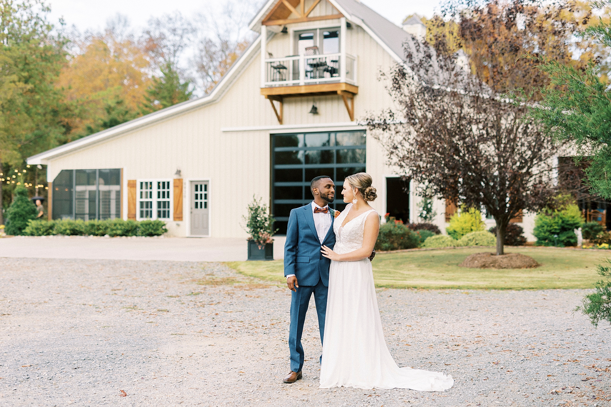 newlyweds hug in front of barn at Bella Terra 