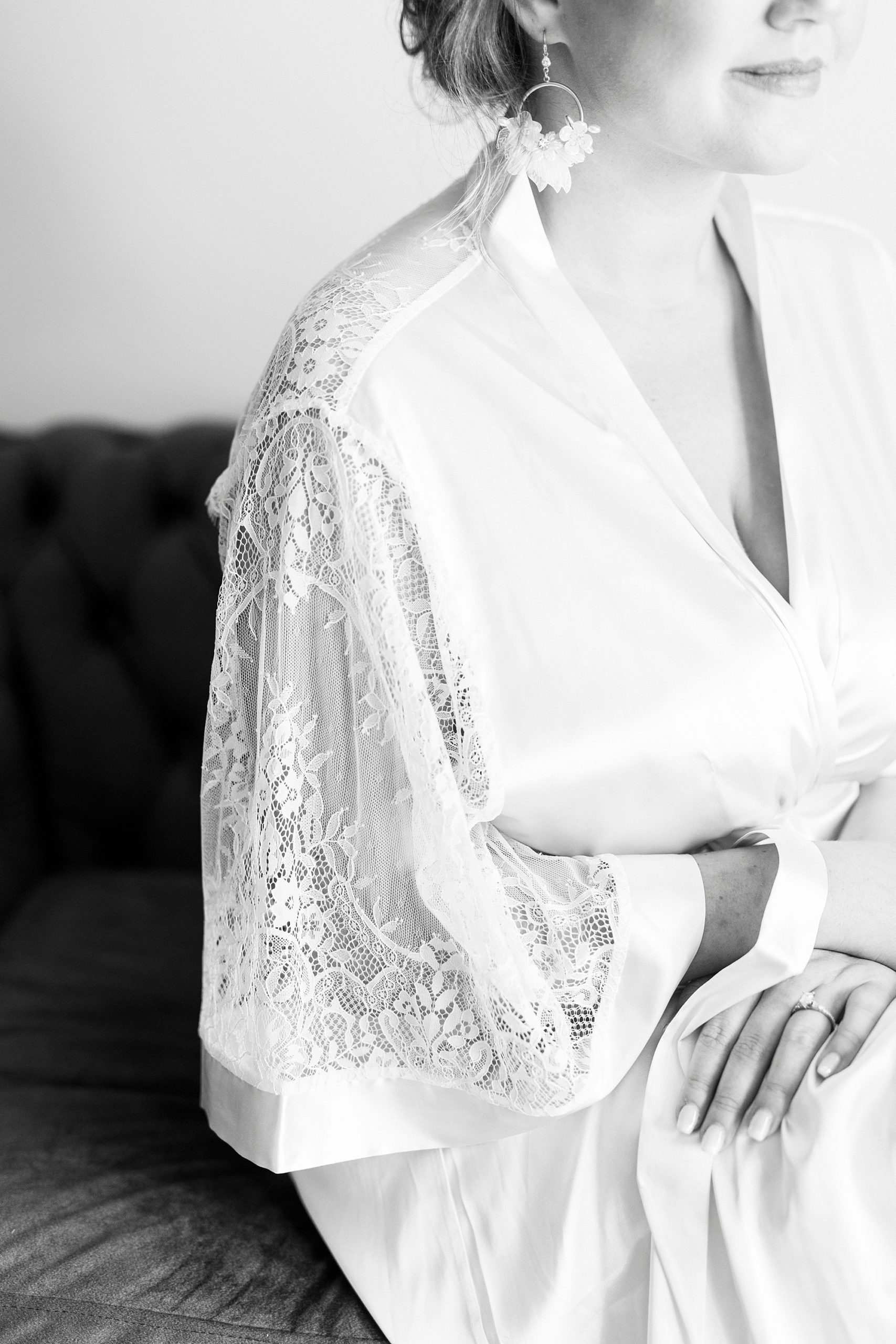bride sits in ivory lace robe in bridal suite at Bella Terra 
