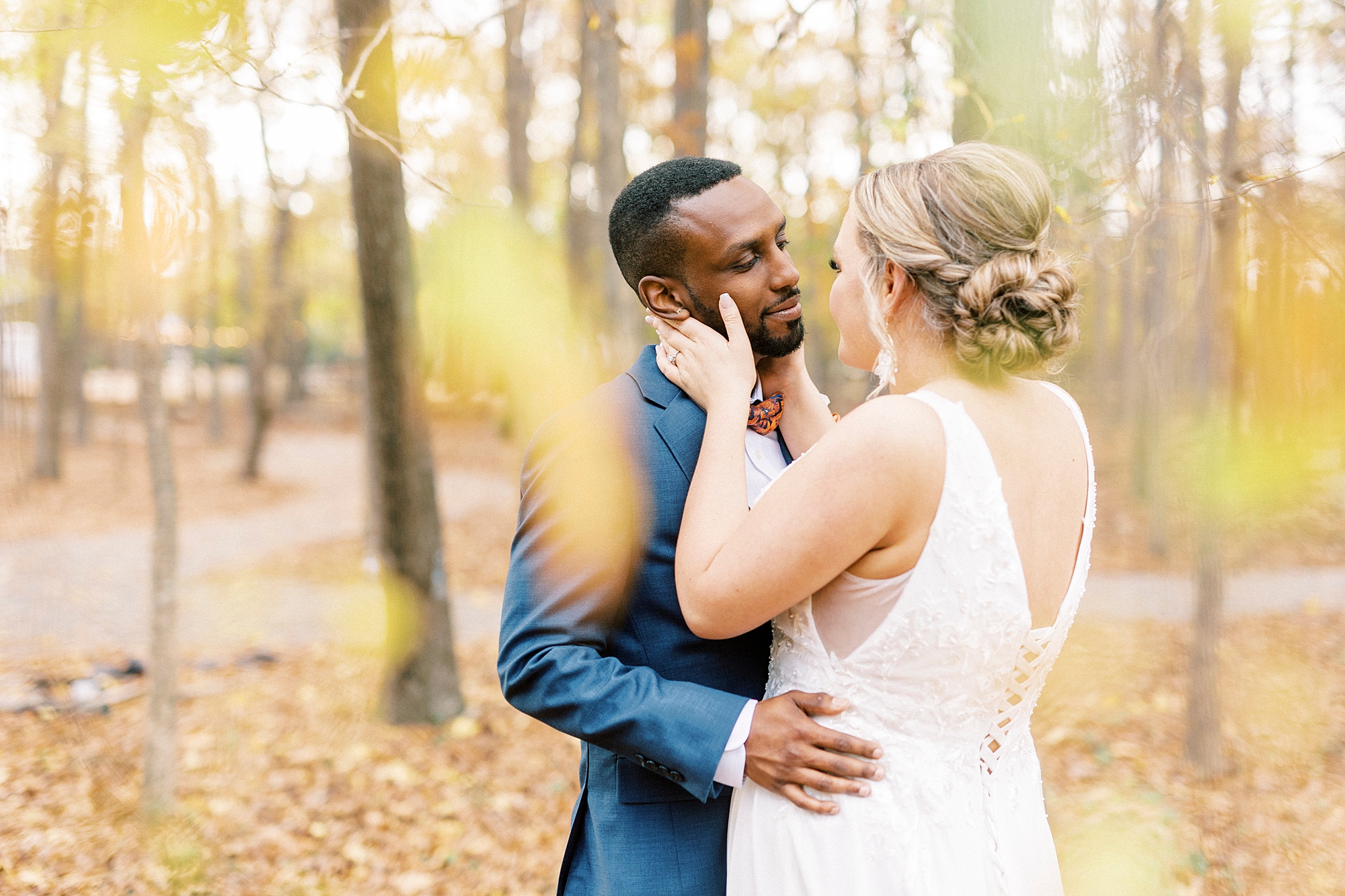 bride holds groom's cheeks to lean in for kiss