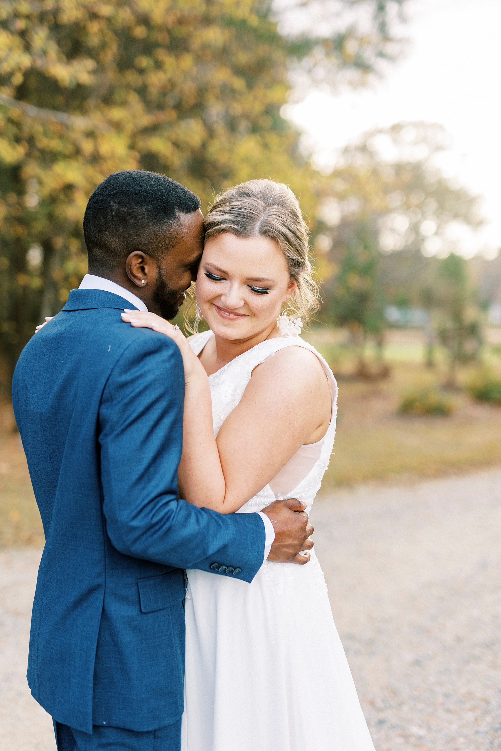 groom nuzzles bride's cheek during fall wedding portraits 