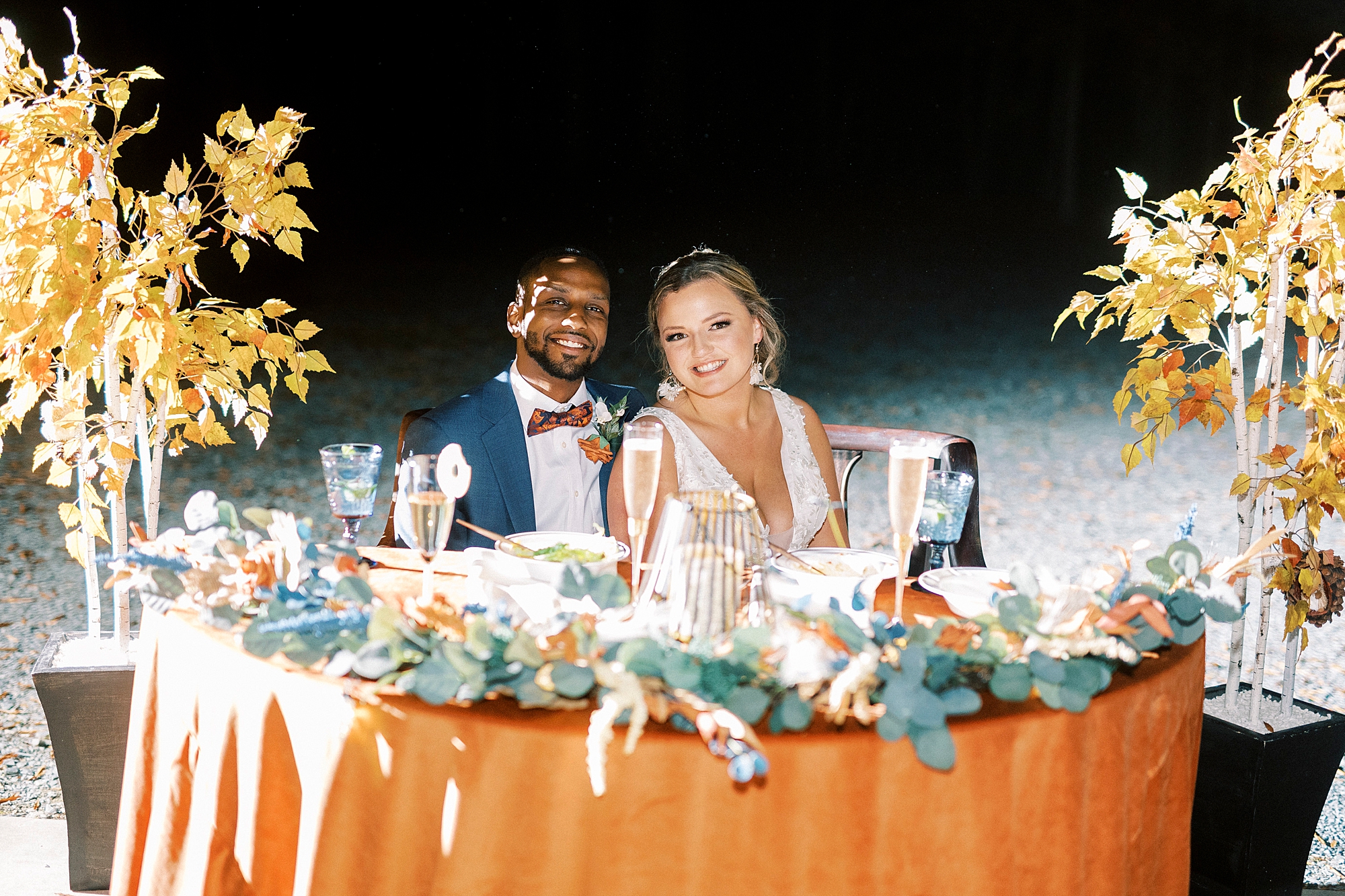 bride and groom smile sitting at sweetheart table during Bella Terra Inc. reception 
