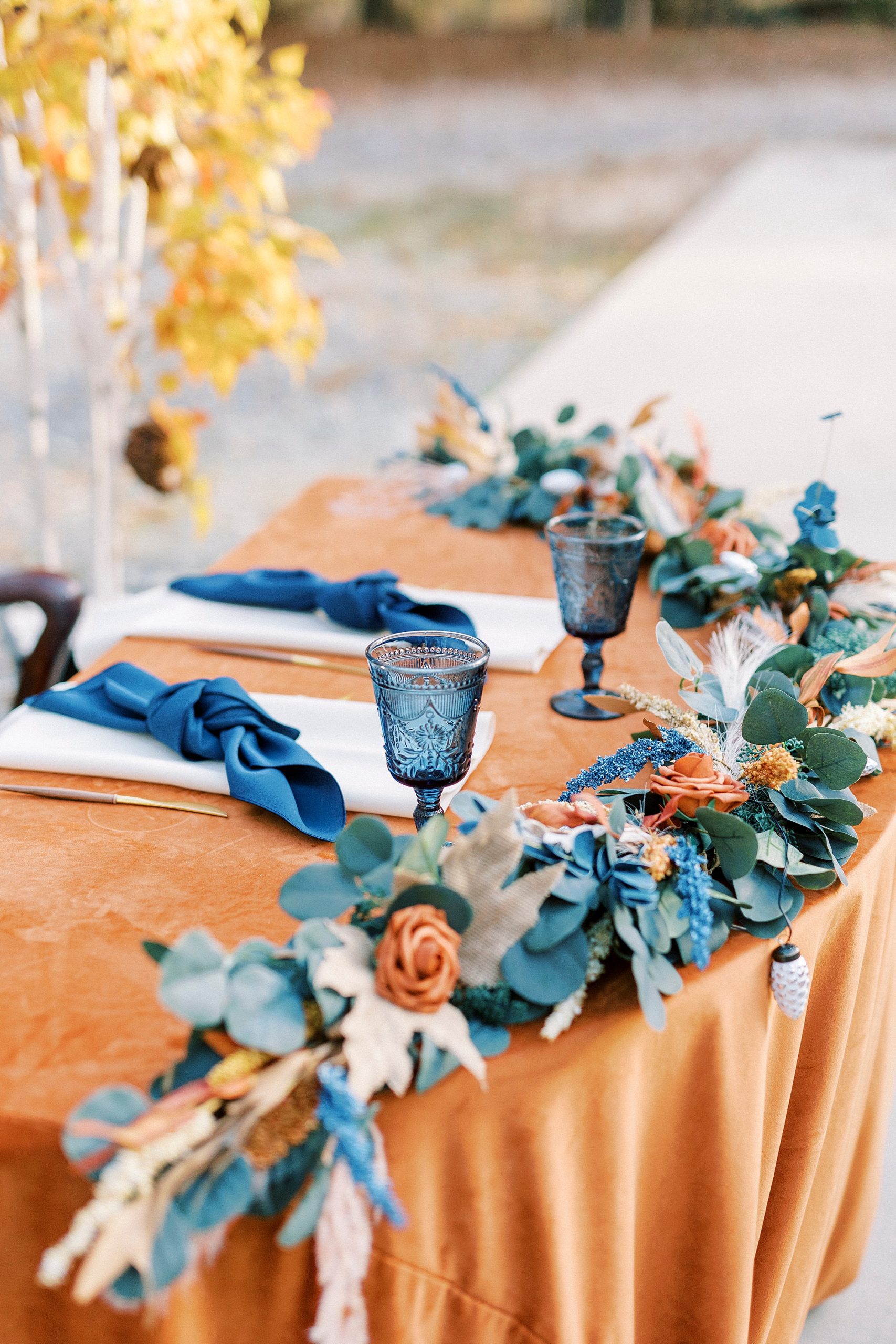 sweetheart table with navy and orange draped around front 