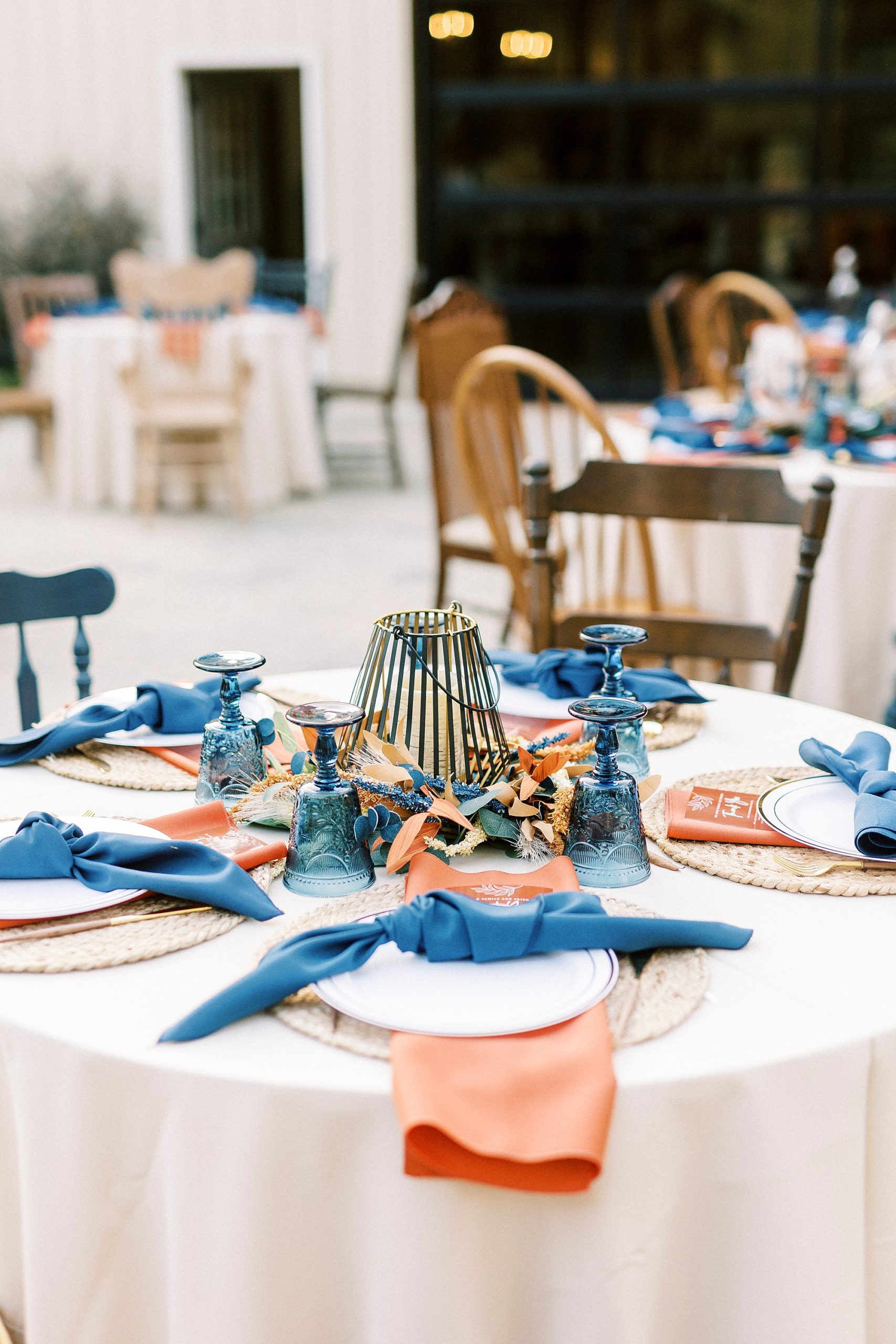 candle centerpieces with orange and blue place settings at Bella Terra Inc.