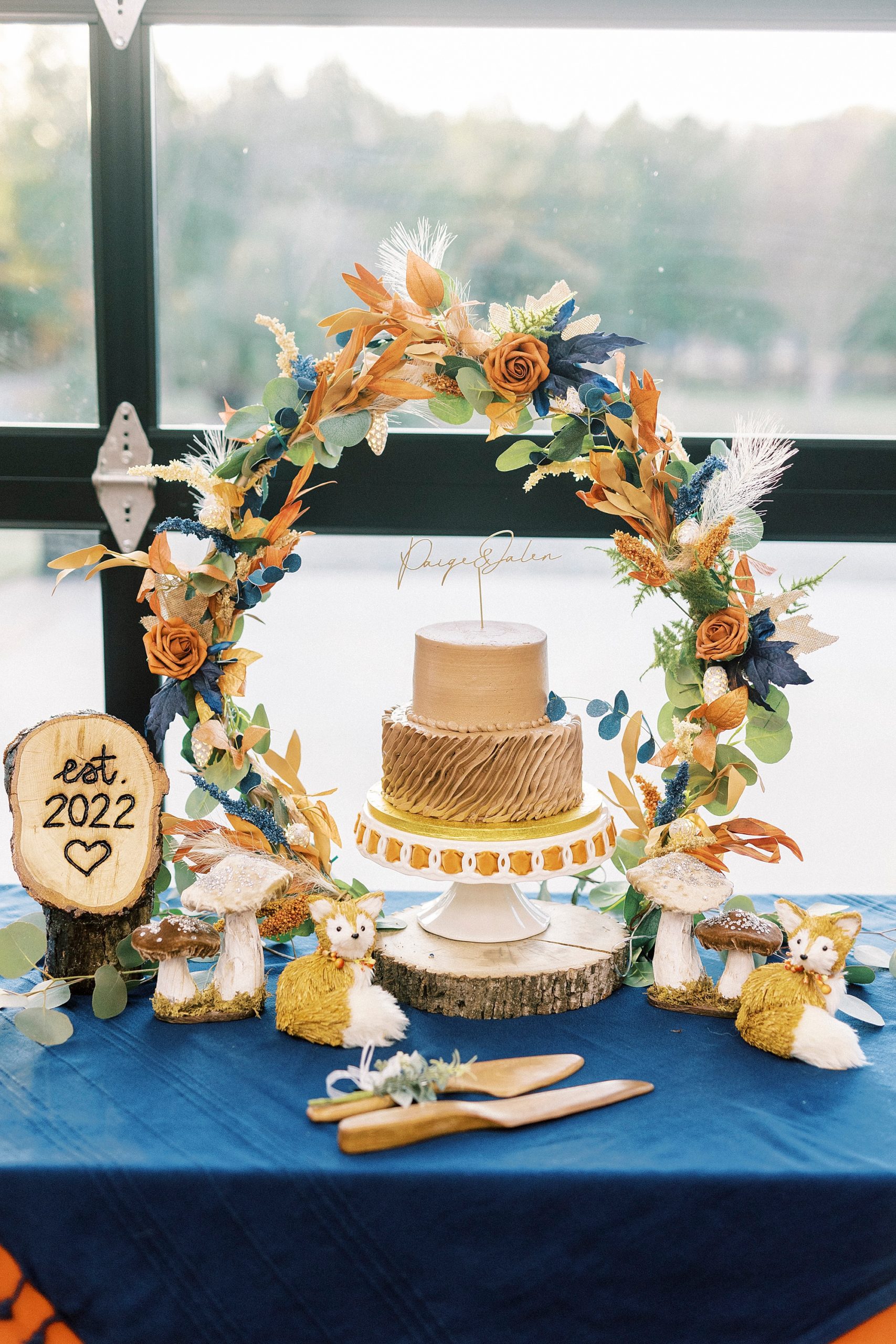 wedding cake under blue and orange arbor at Bella Terra Inc.